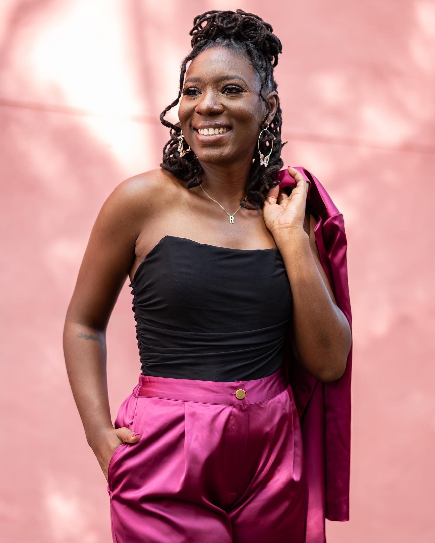Person in black top and pink skirt poses against pink background in a series of fashion portraits.
