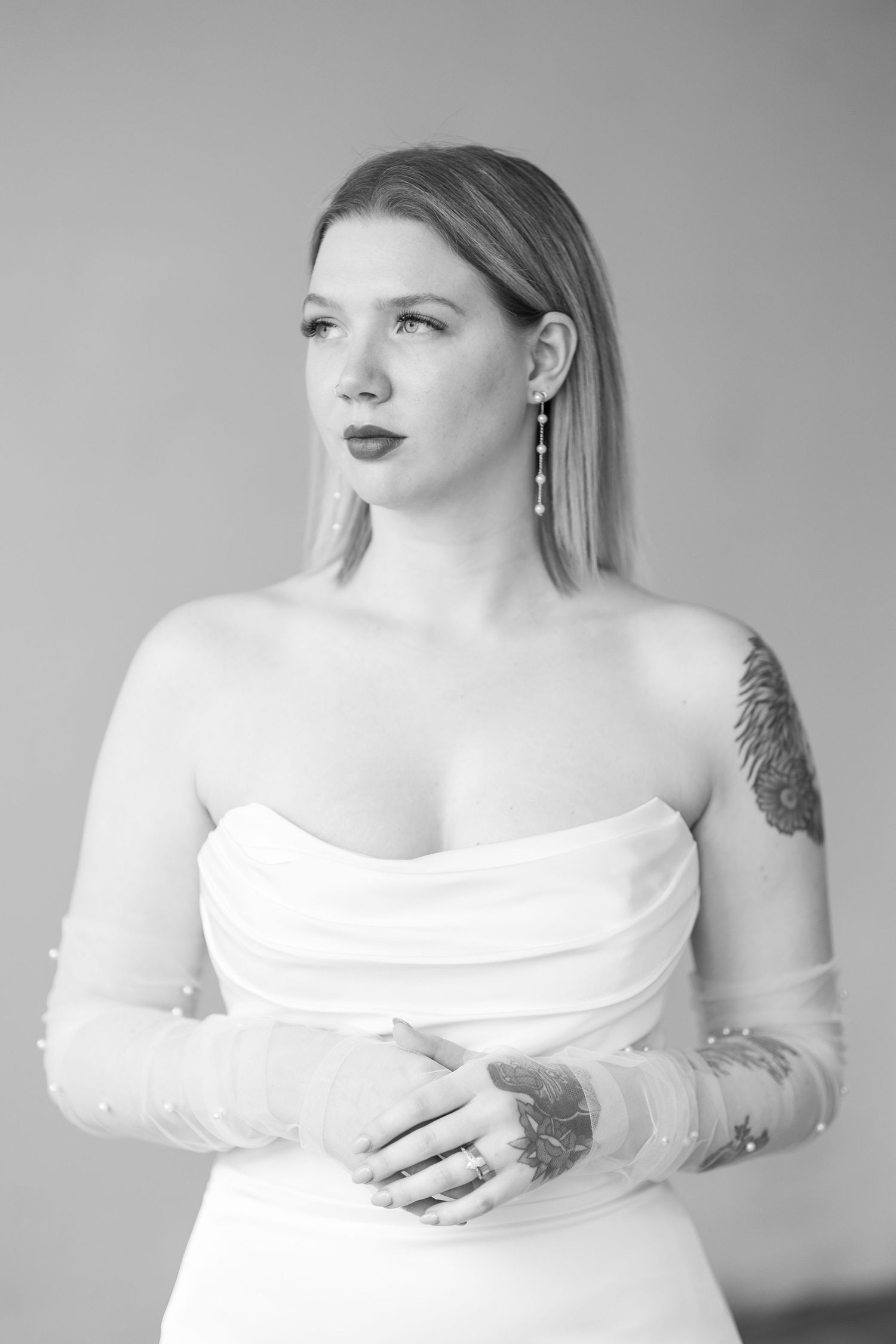 Elegant portrait in white dress against grey background.