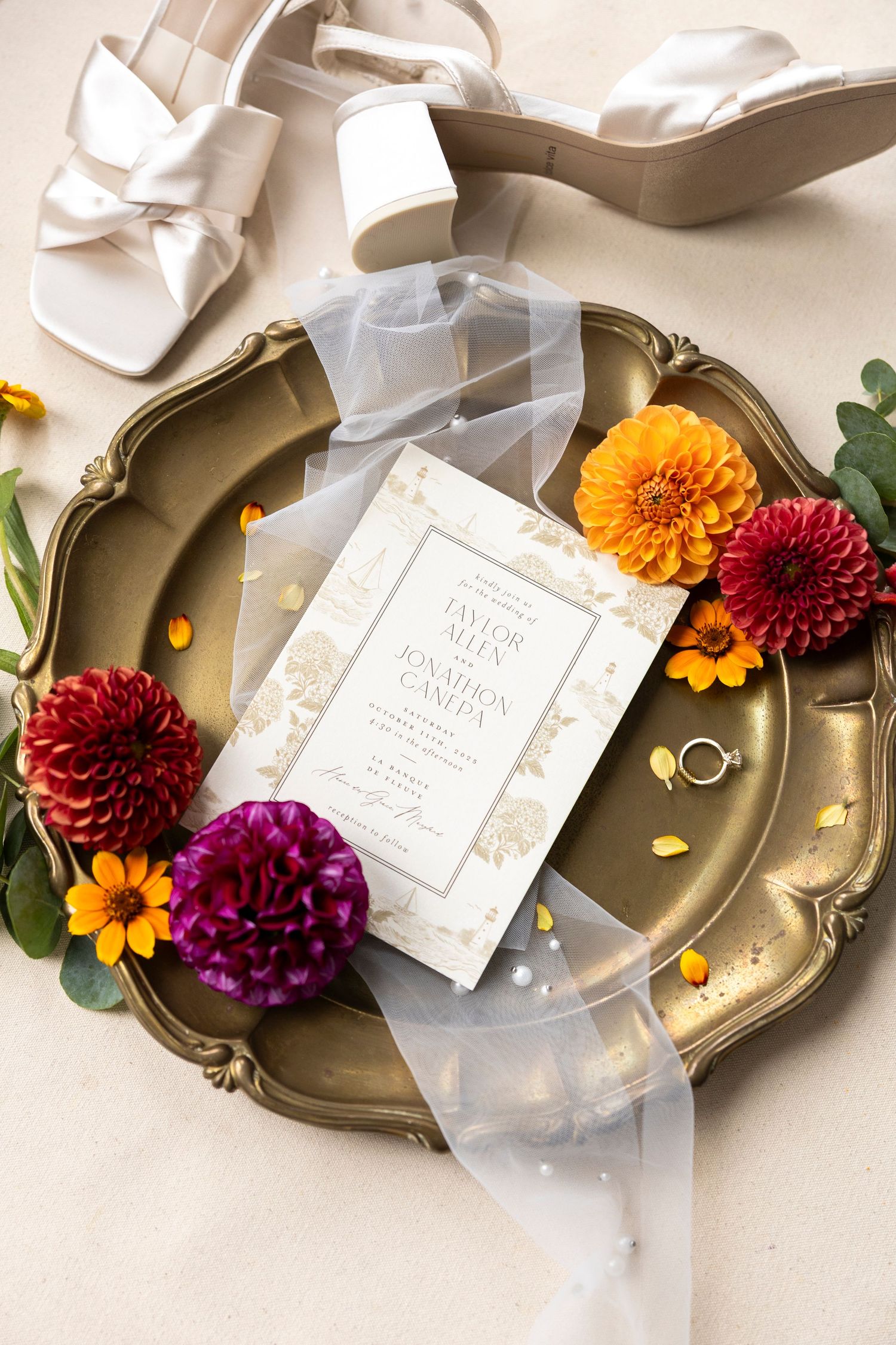 Wedding details arranged on antique silver tray with colorful dahlias and white ribbon.