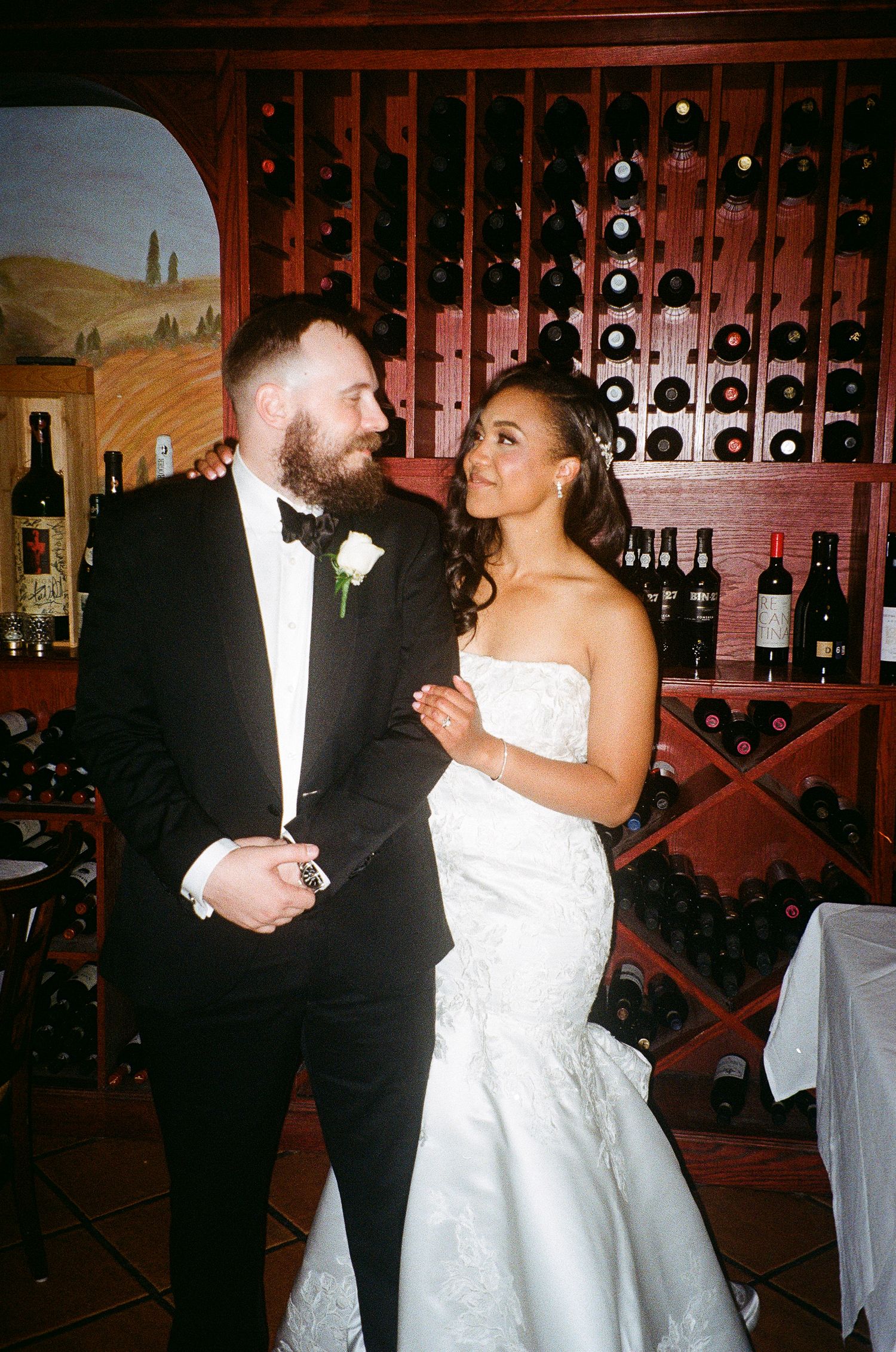 Celebratory scene in front of wooden wine storage racks at an event venue.