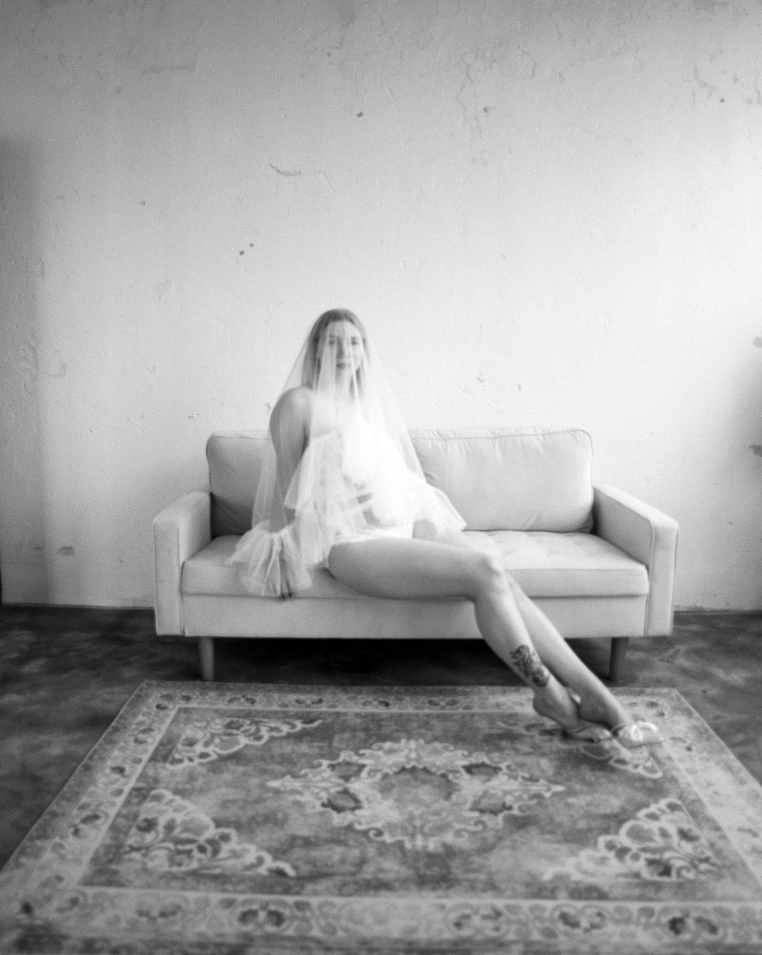 Black and white photo series showing figure reclining on couch with oriental rug.