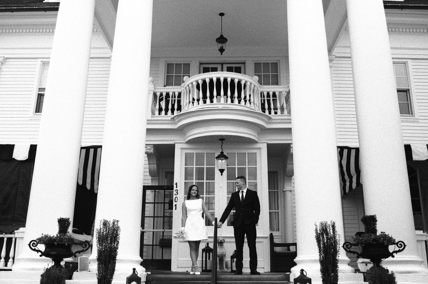 Elegant white colonial building facade with tall columns and balcony.