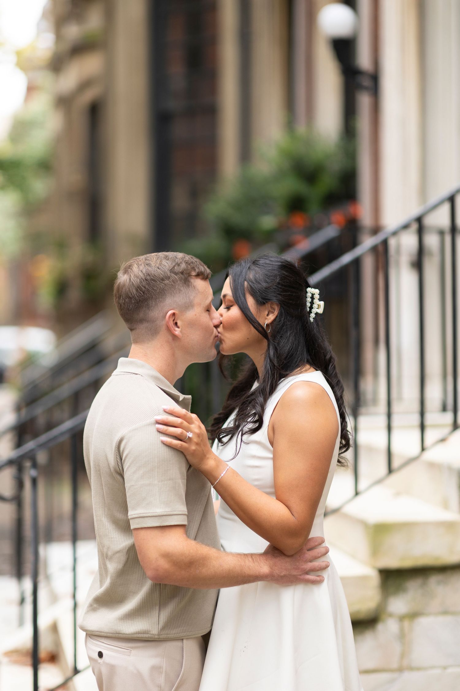 Tender romantic moment shared between couple on city sidewalk during engagement photos.