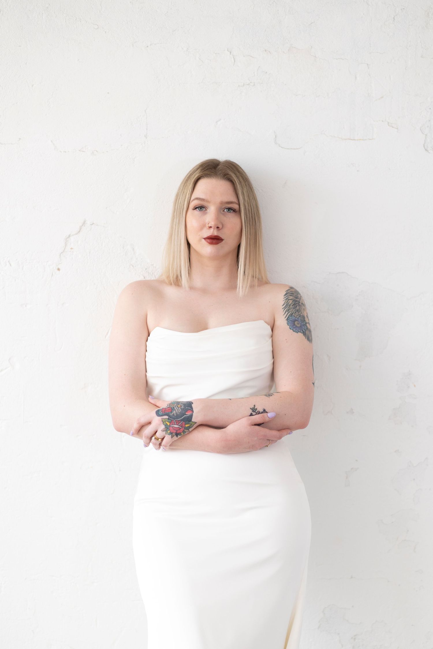 Studio portraits against white wall showing person in draped white fabric.