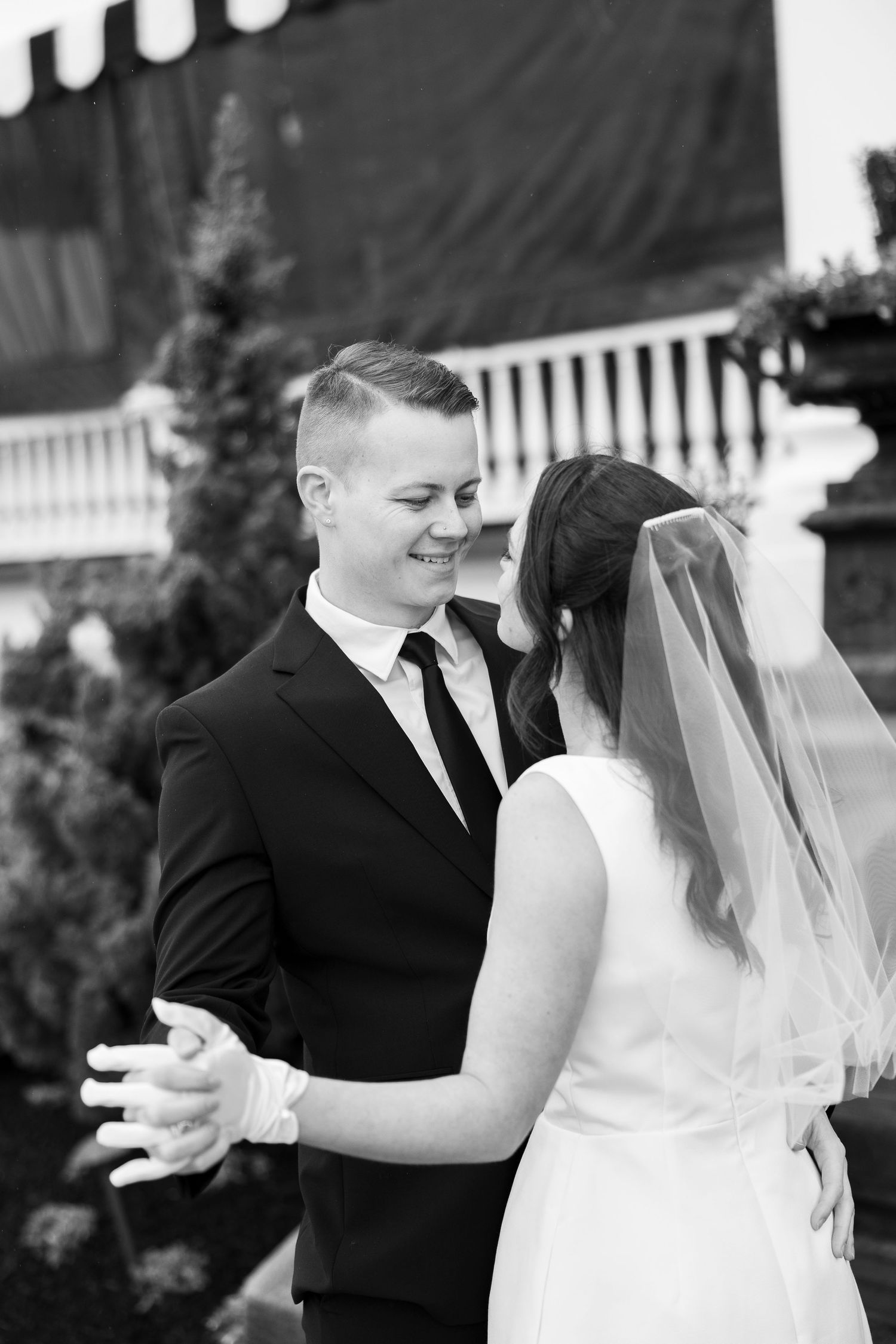 A couple shares candid laughter during their outdoor wedding photoshoot.