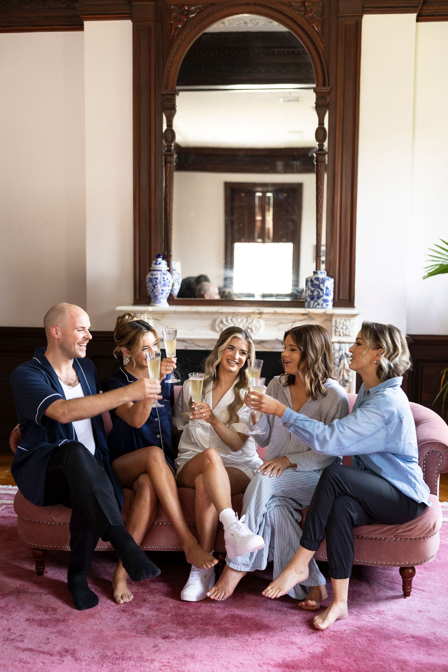 Wedding party relaxing casually on purple carpet in elegant room with wood trim.
