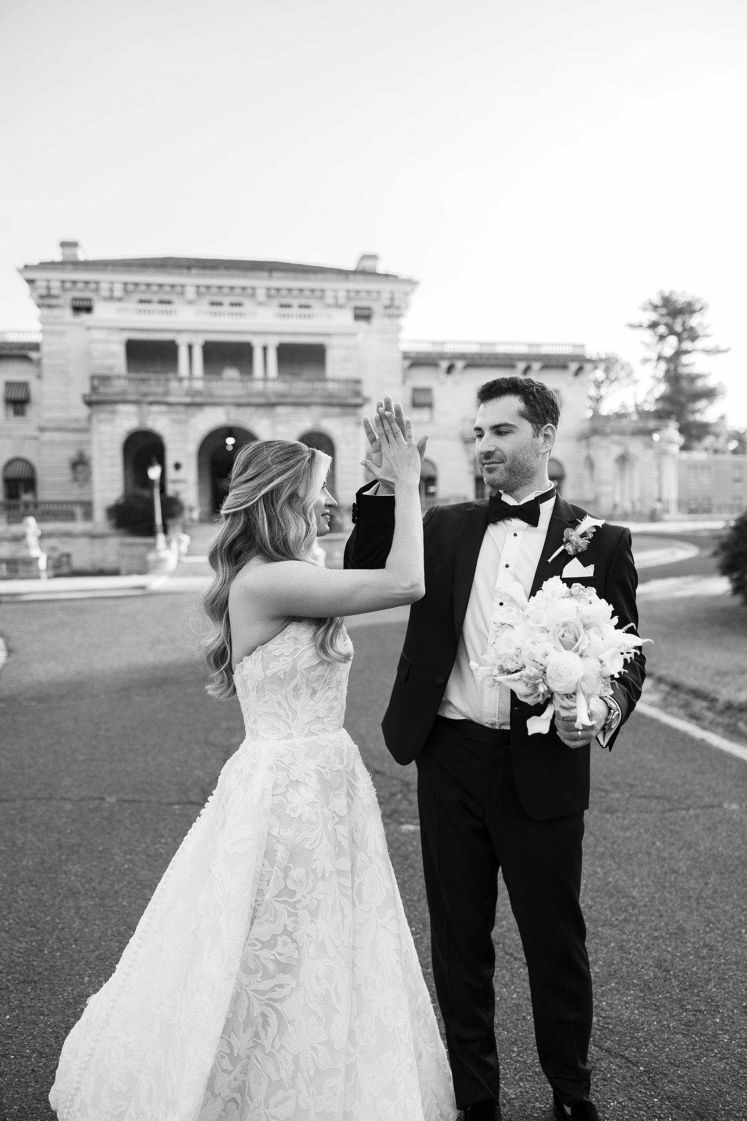 Black and white sequence of a couple posing in front of an elegant stone mansion.