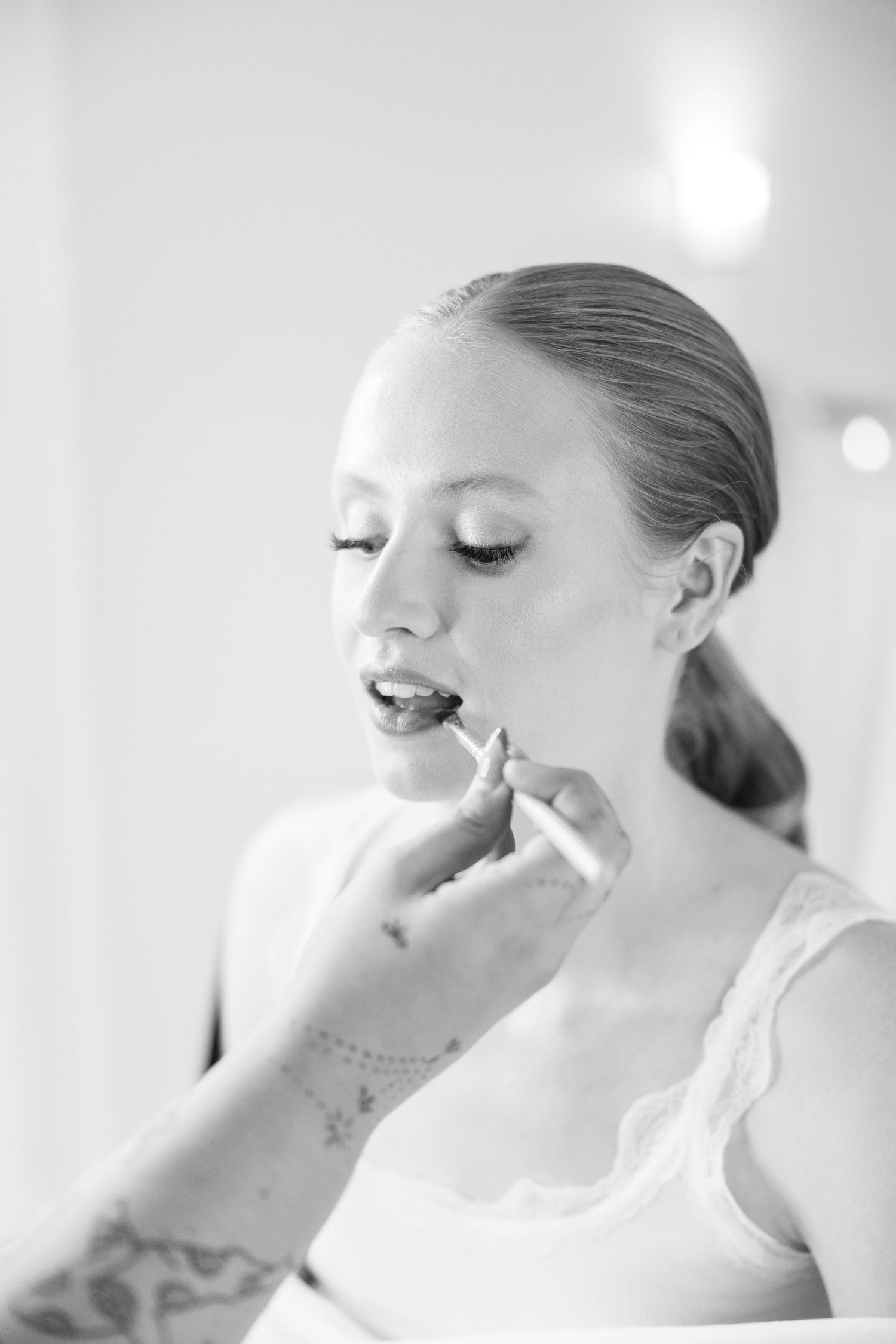 Close-up artistic black and white portrait shots showing delicate makeup application.