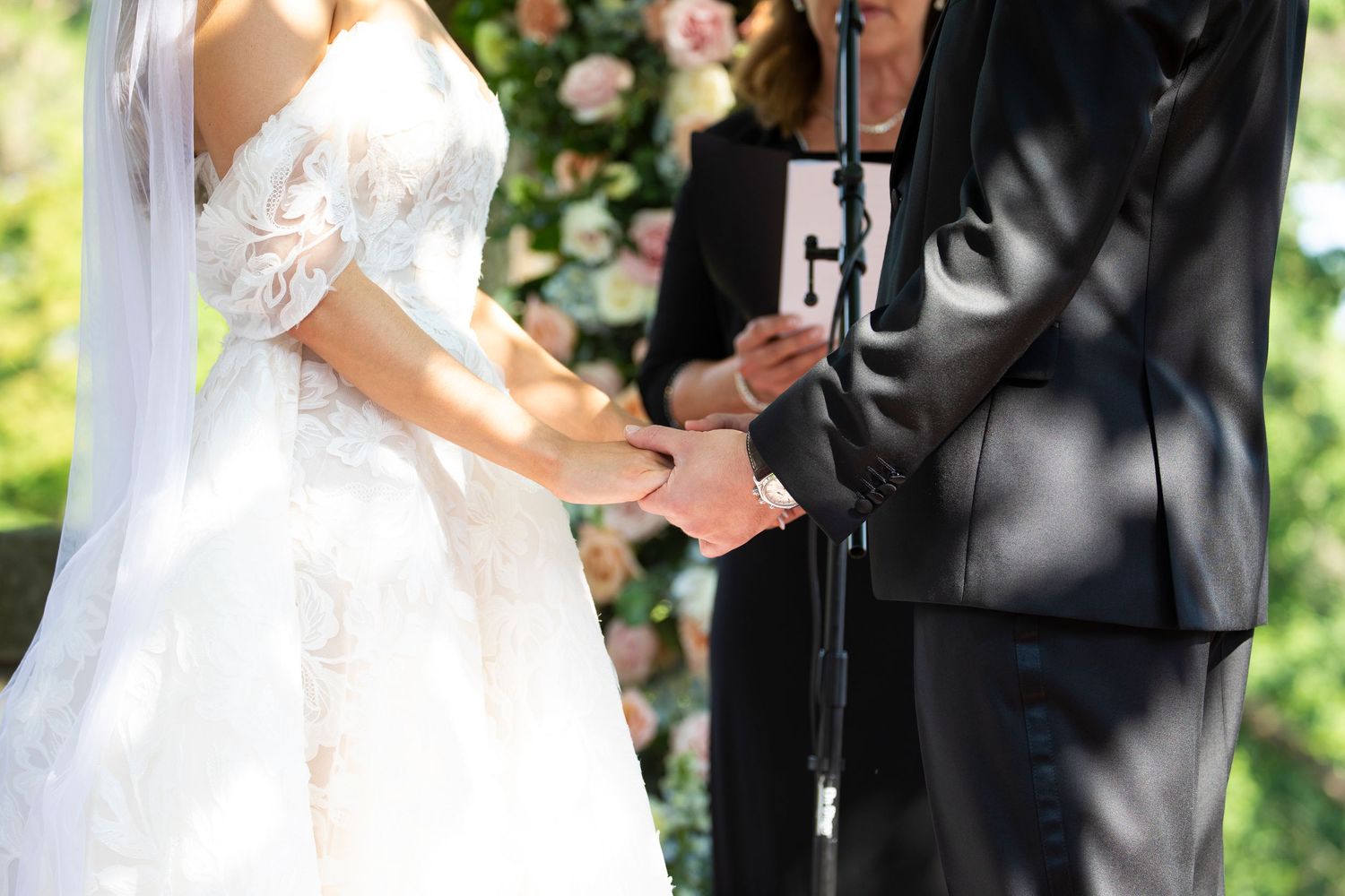 A couple shares an intimate moment during their wedding ceremony surrounded by floral decorations.