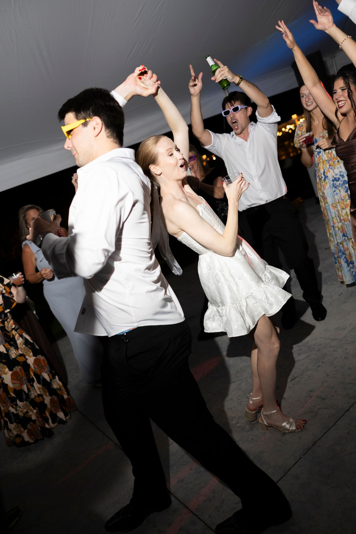 Wedding reception dance floor filled with guests dancing and celebrating.