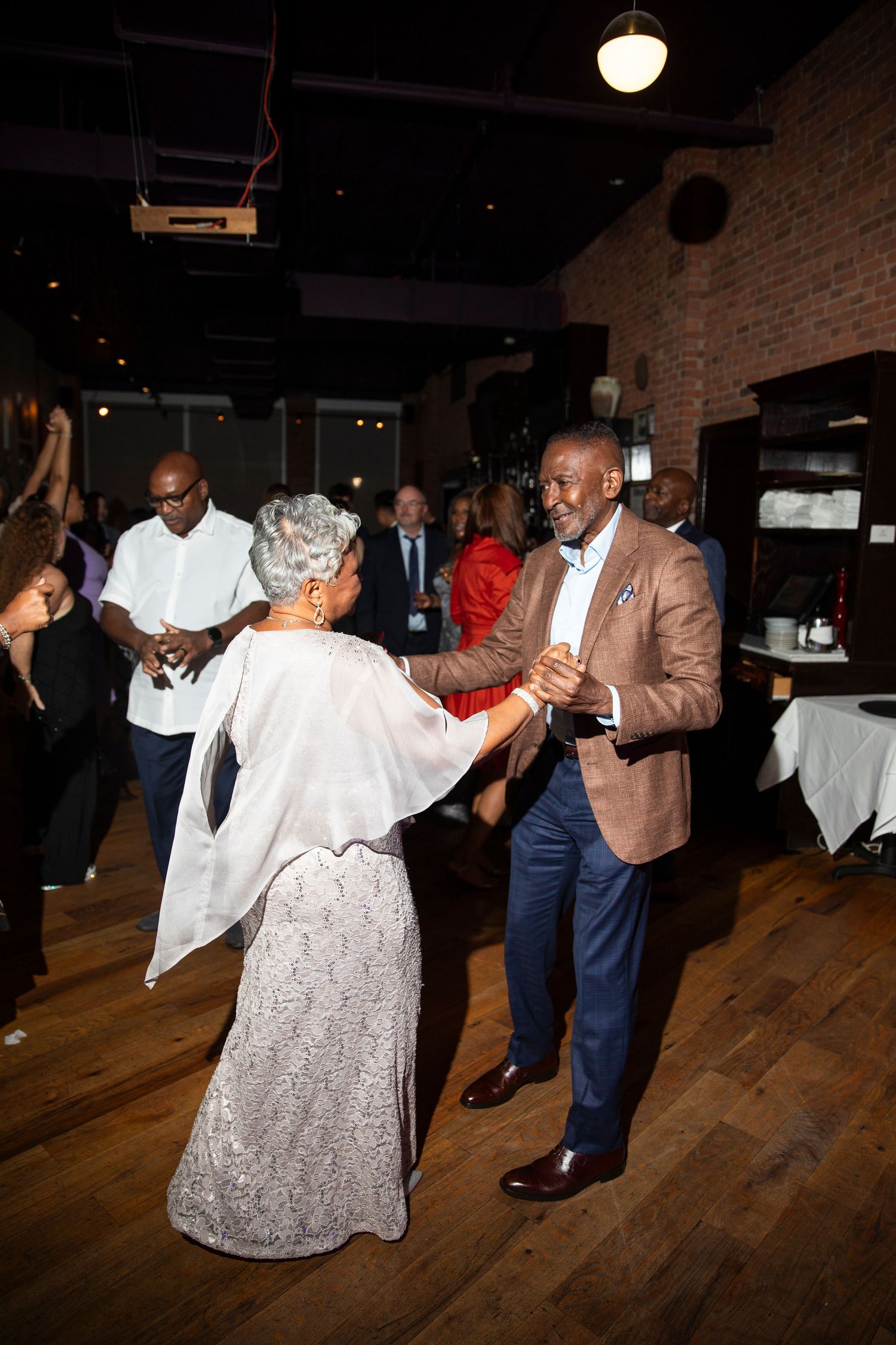 Wedding guests dancing and enjoying themselves on the dance floor.