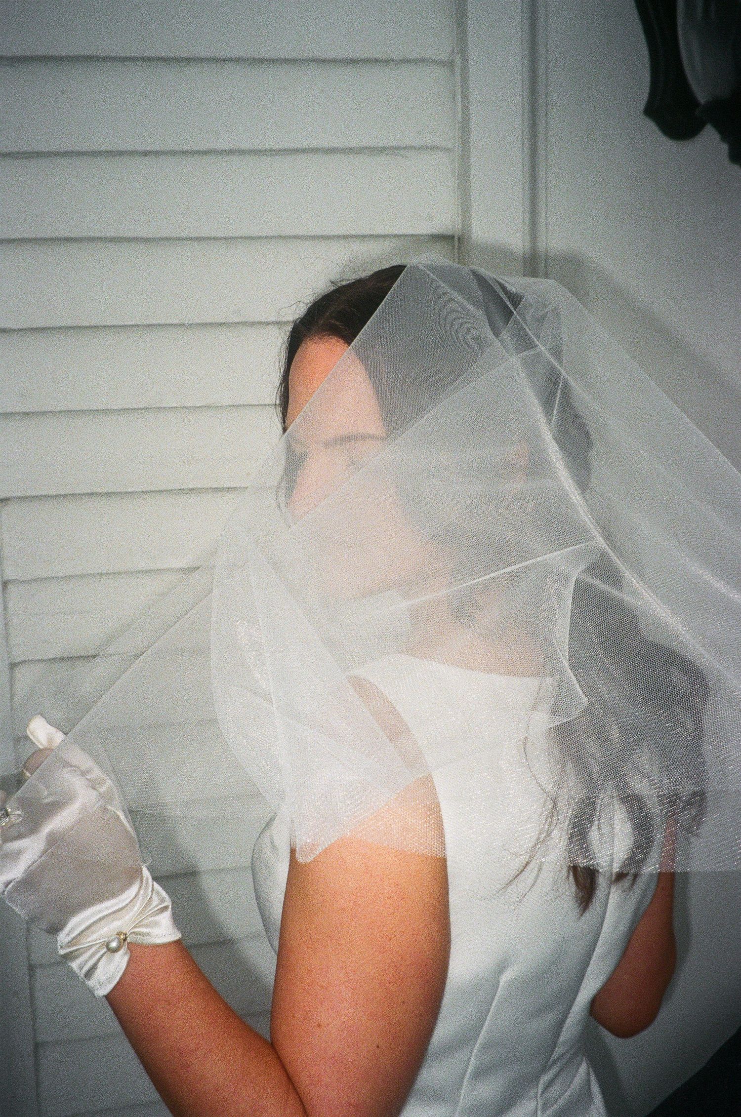Close-up shots of a delicate white wedding veil with soft lighting.