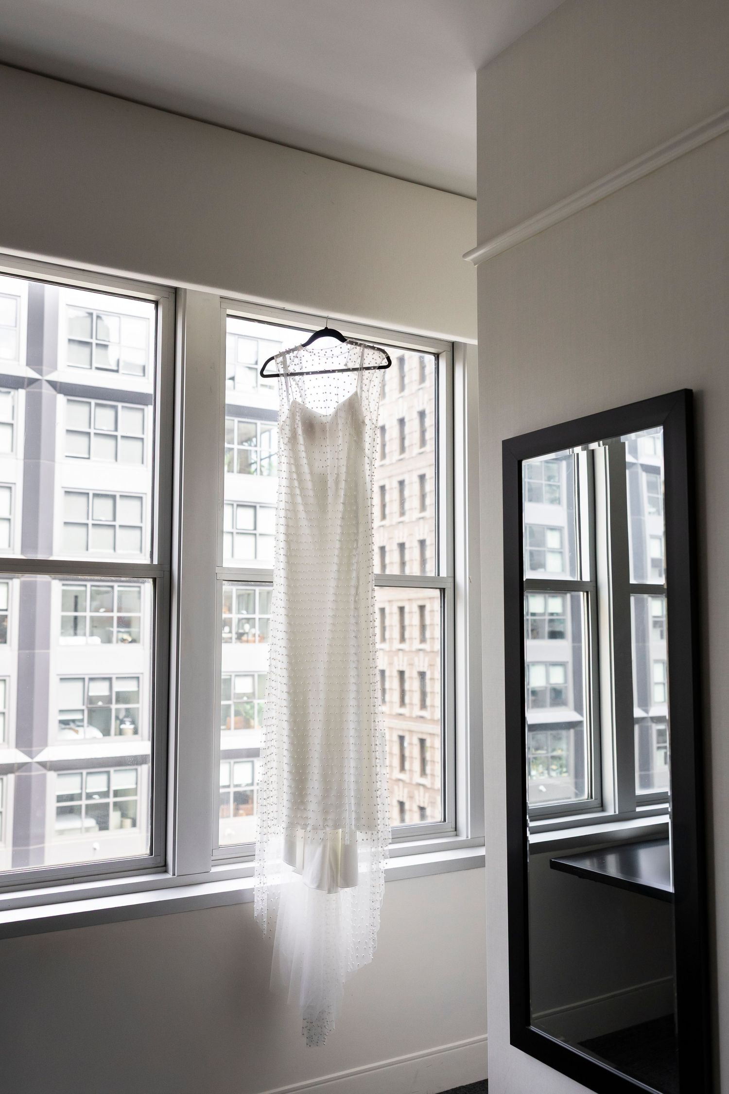 Minimalist white room interior with large windows and natural lighting.