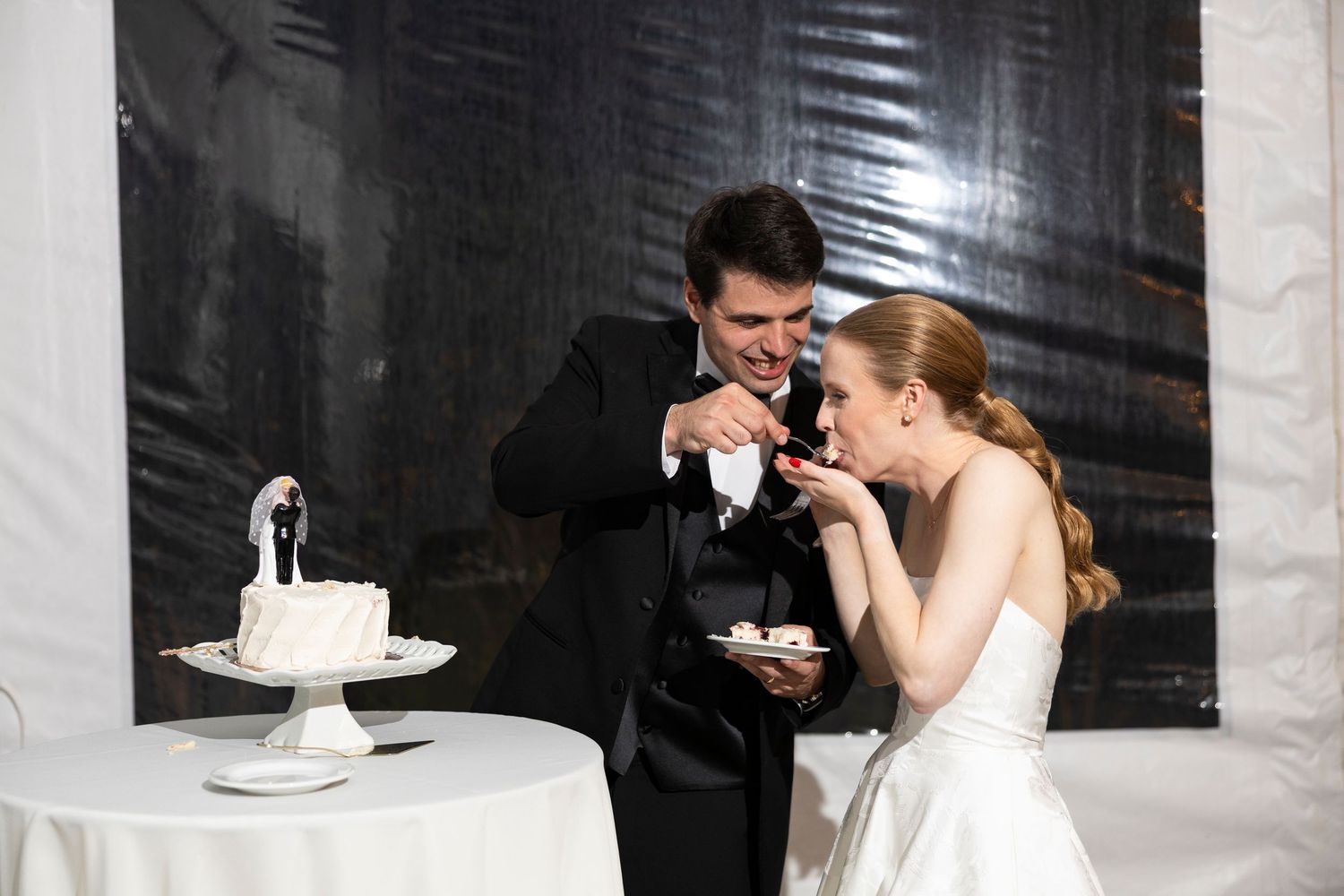 Black and white wedding photo series showing couple sharing cake at reception.