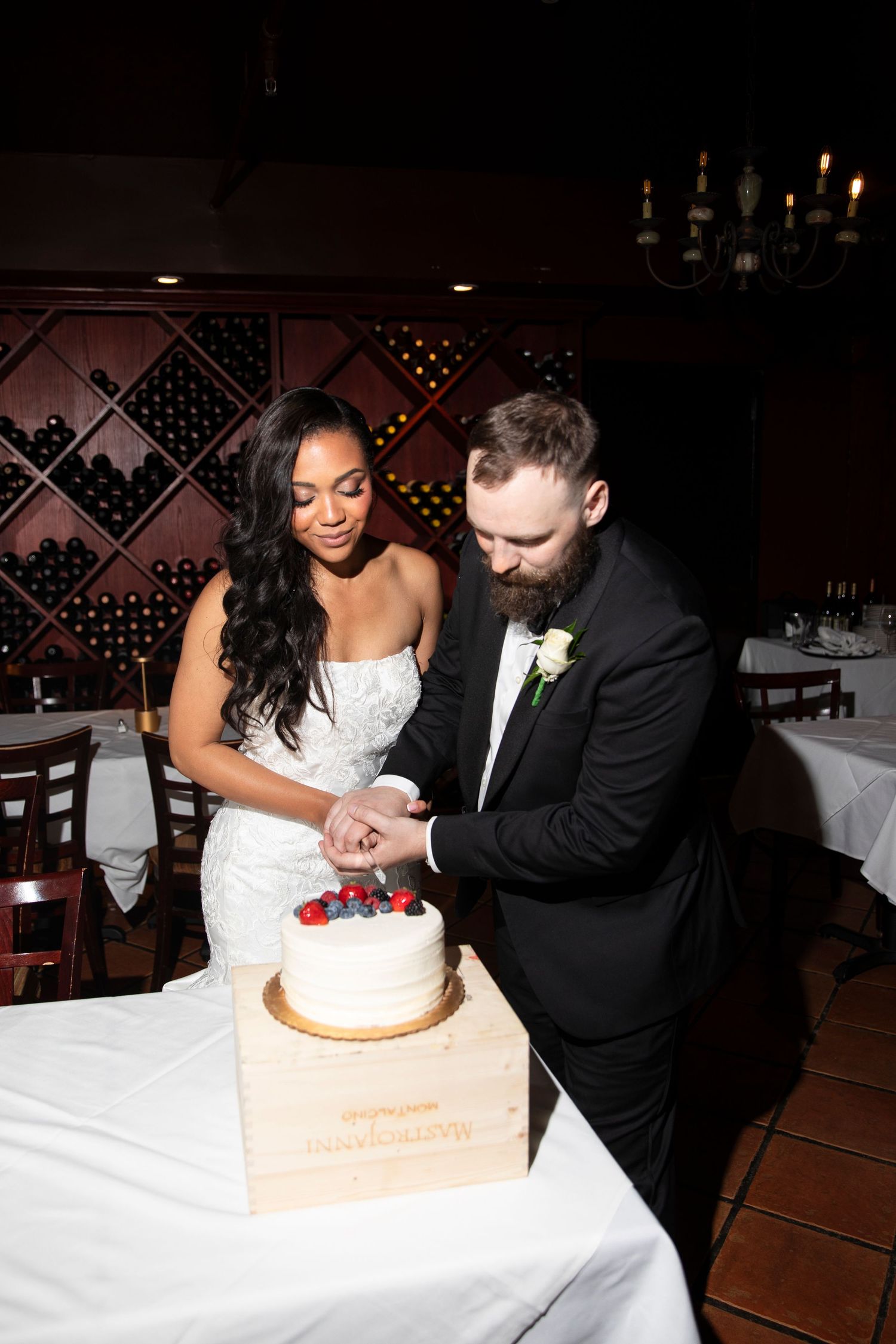 Newlyweds cutting their wedding cake together at the reception.