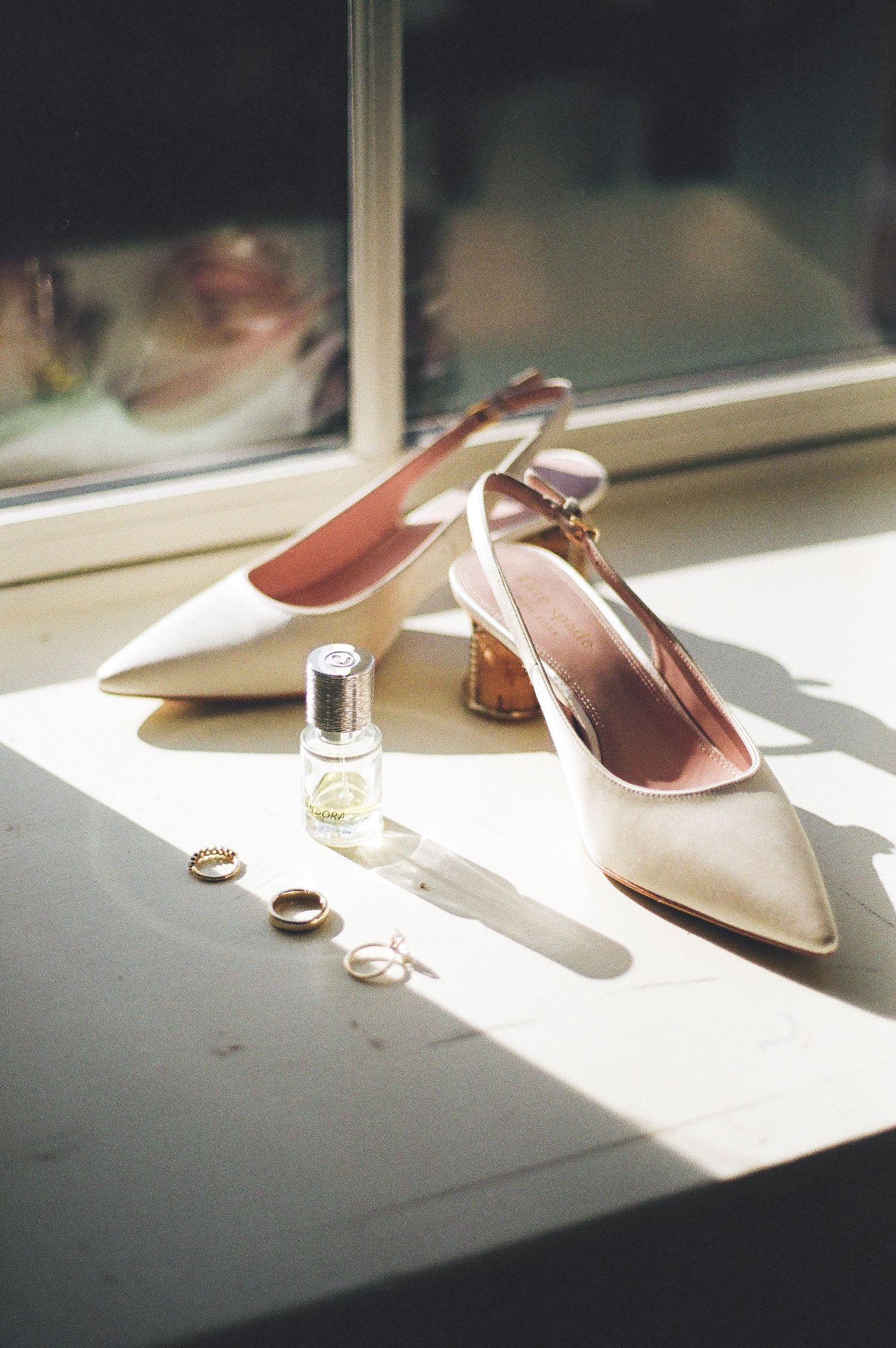 Wedding accessories and shoes arranged artistically in natural window light.