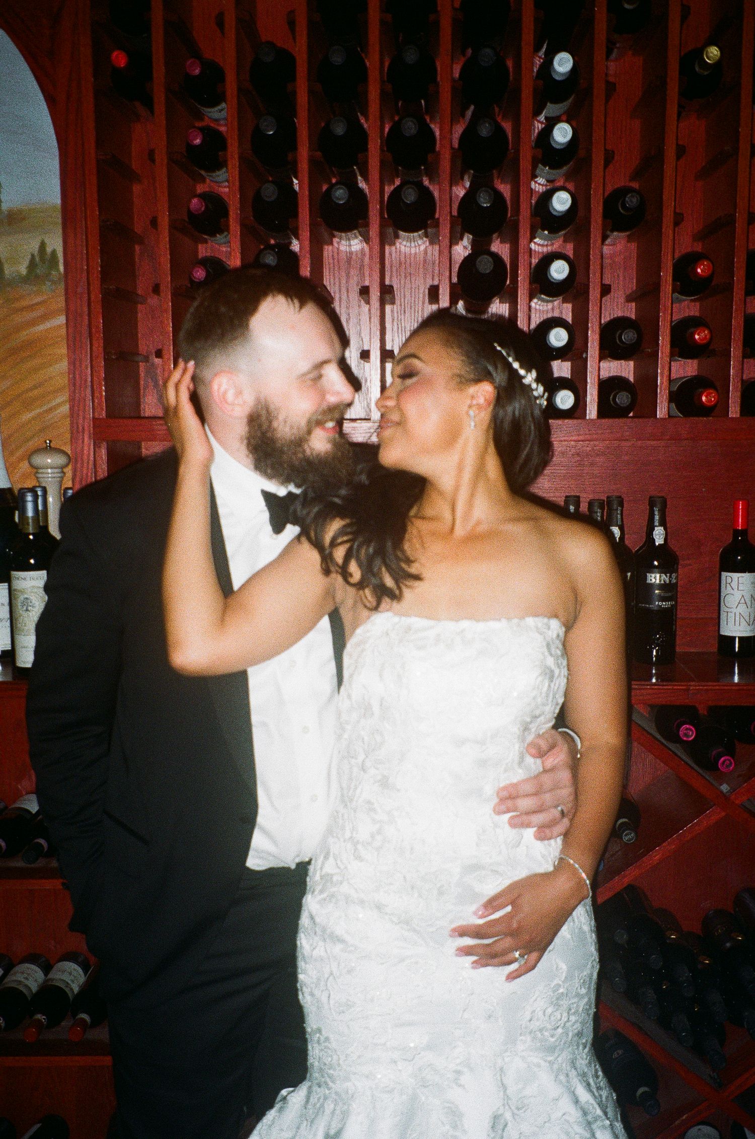 Romantic moment in a wine cellar with wooden wine racks in the background.