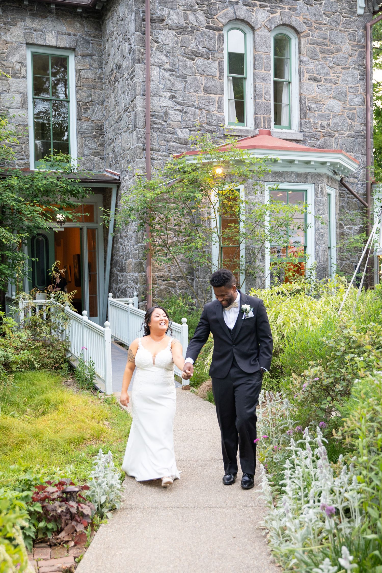 Stone building with flowering garden path creates romantic wedding venue atmosphere.