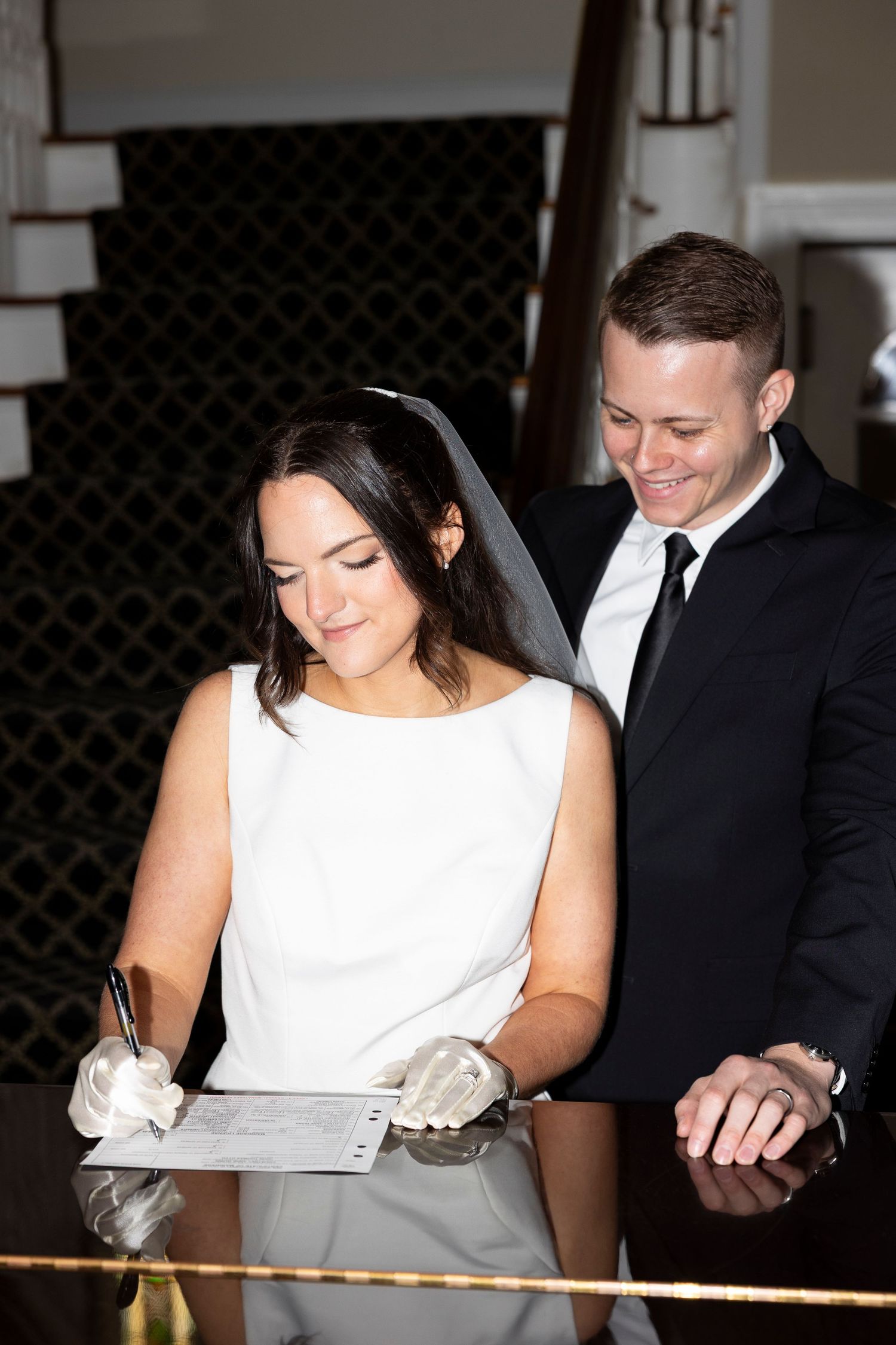 Couple reviewing paperwork together in formal wedding attire.