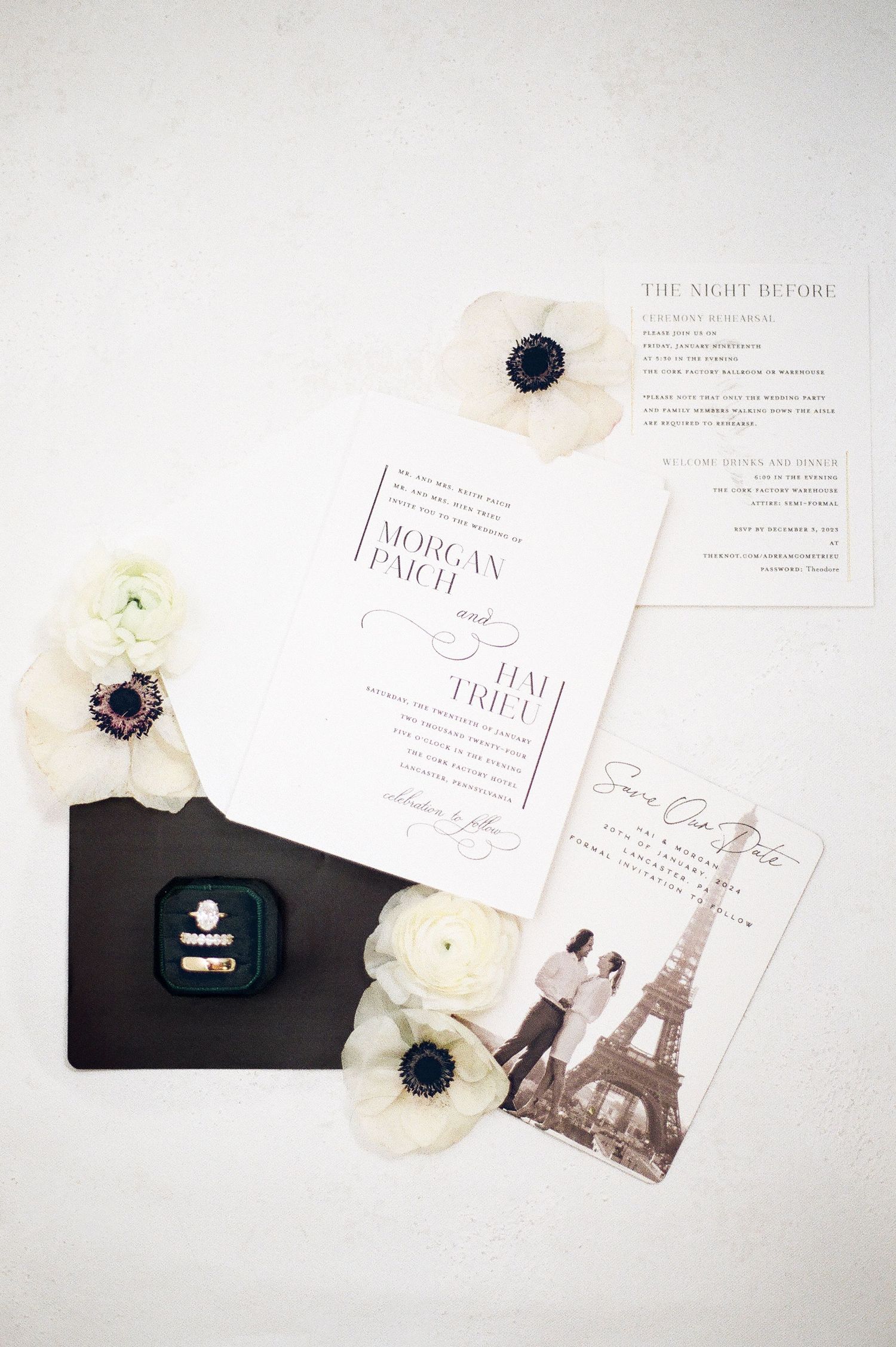 Wedding invitation suite featuring Paris Eiffel Tower theme with delicate white flowers and elegant typography.