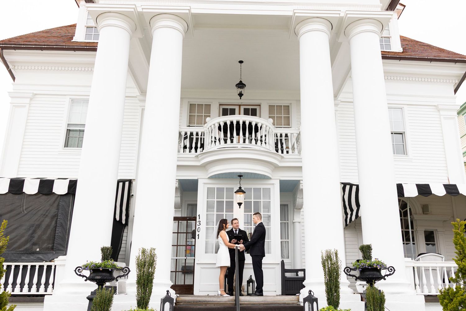 Elegant white colonial style building with columns and arched windows serves as wedding venue.
