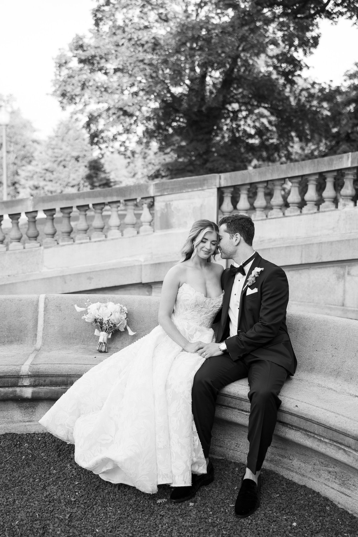 Black and white romantic moments captured on stone steps of a historic venue.