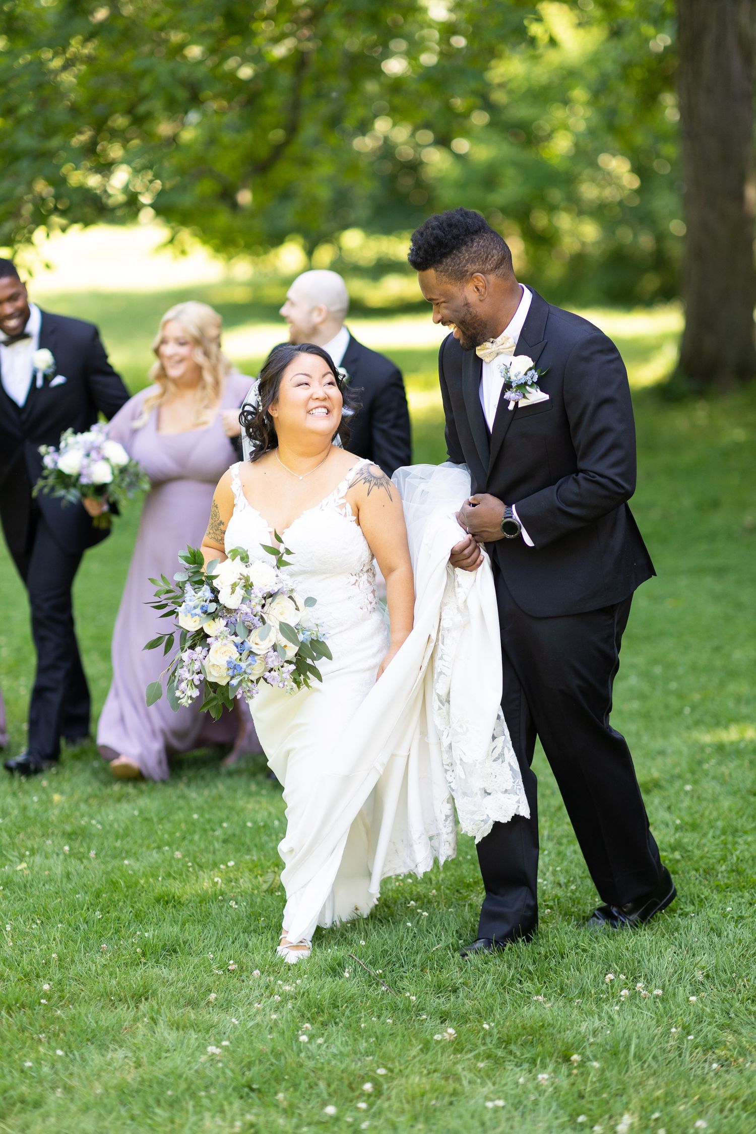 Candid moments of wedding party having fun on grassy lawn during photo session.
