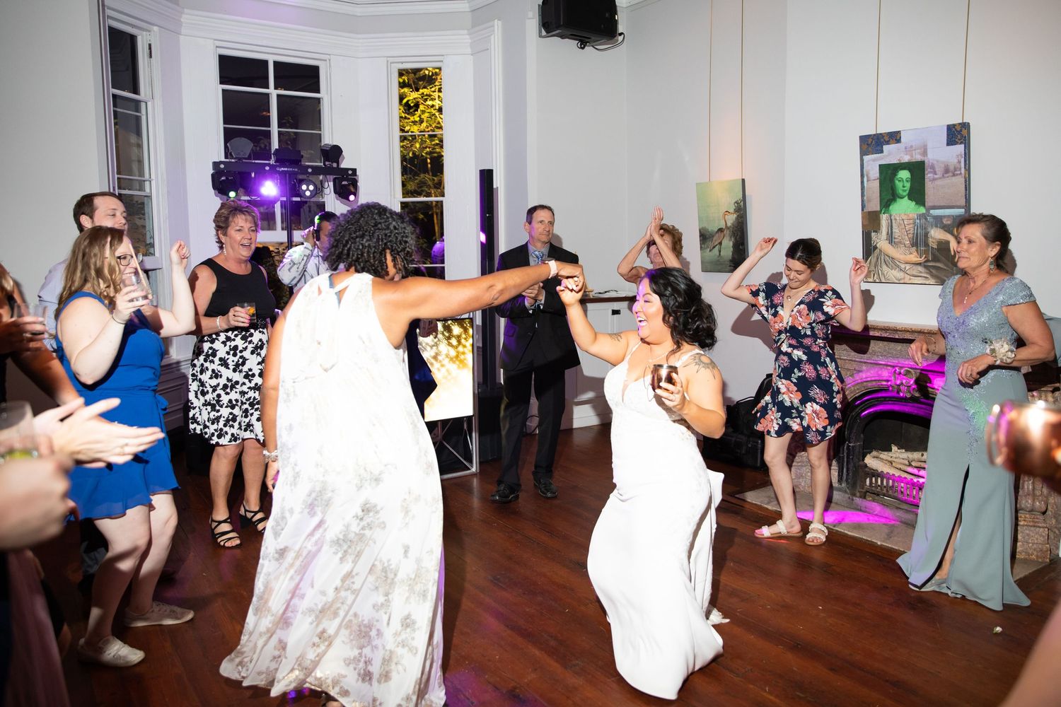Guests enjoying themselves on a lively dance floor at an indoor wedding celebration.