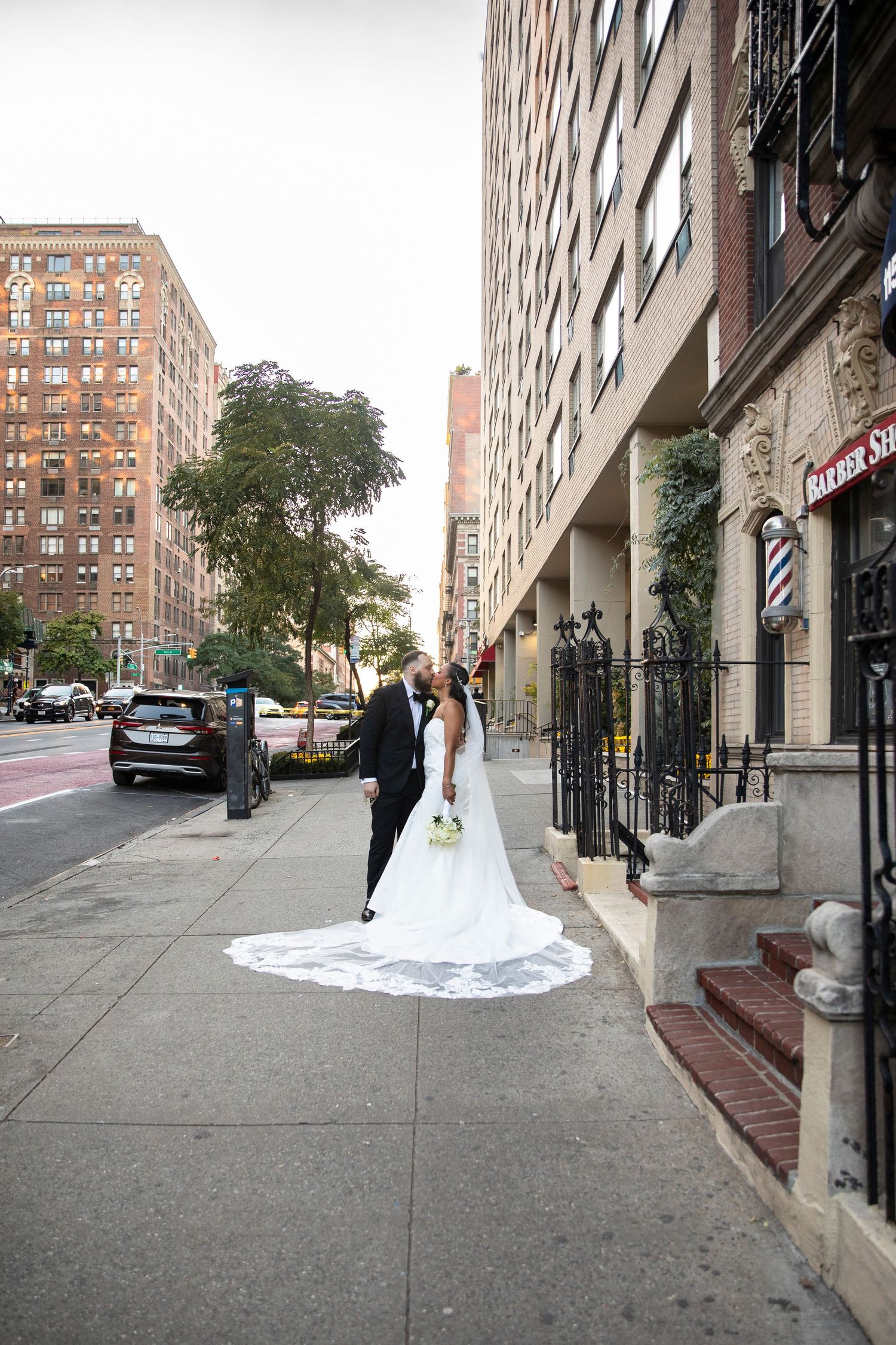 Urban wedding scene with couple standing before classic New York City architecture.