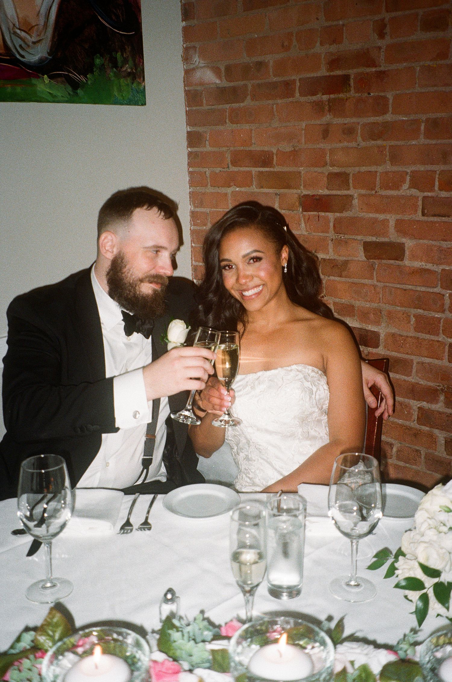 Wedding celebration at an intimate venue with brick walls and candlelit tables.
