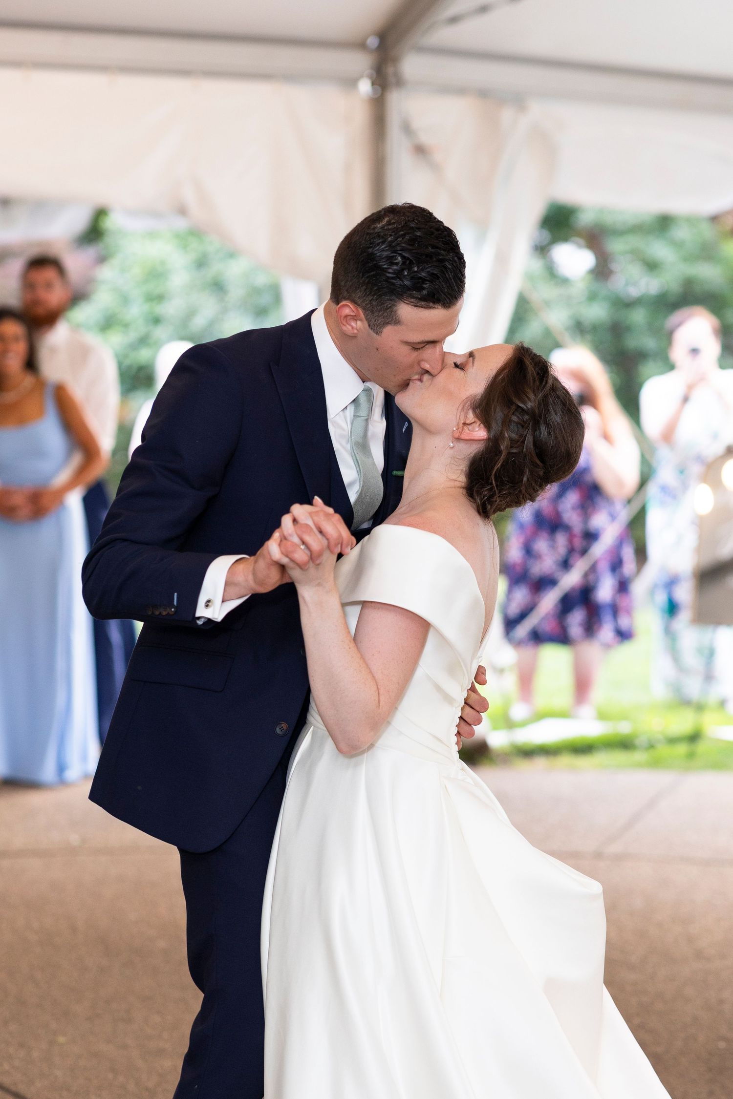 A couple shares a romantic dance under a tent during their wedding celebration.