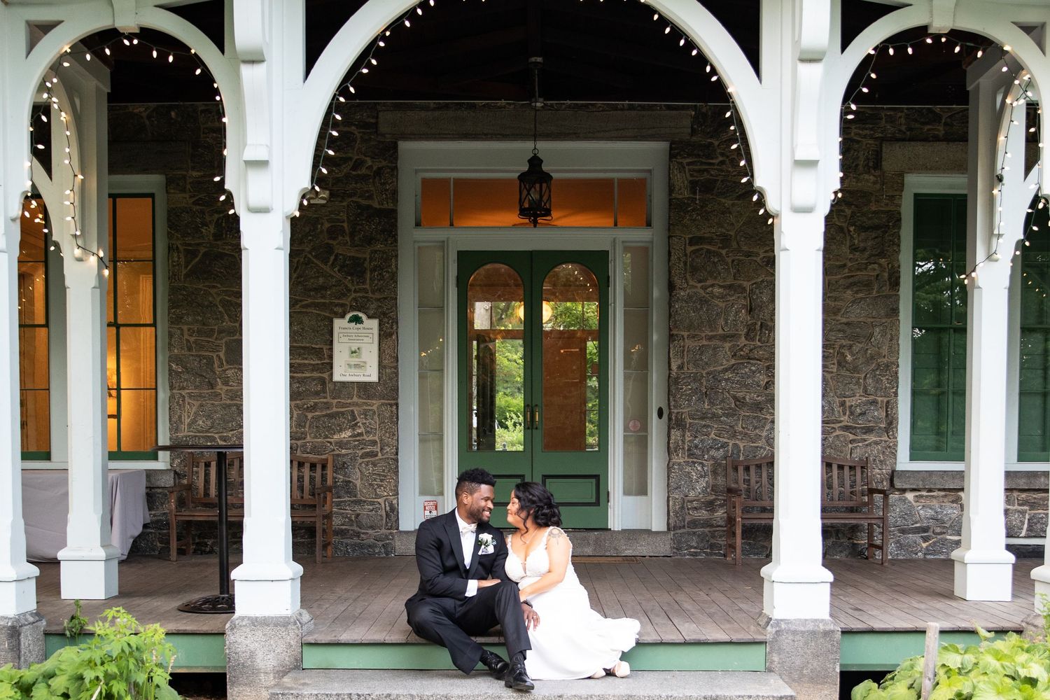 Stone building with white pillared archways creates an elegant wedding venue setting.