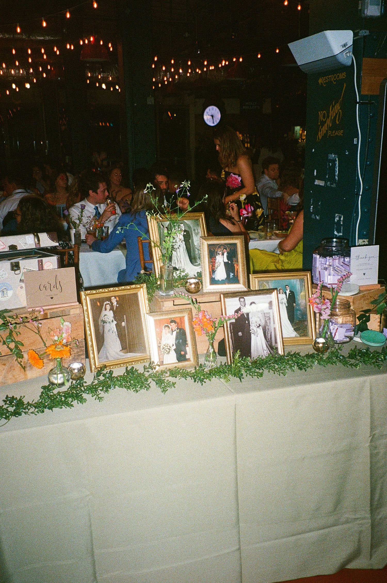 Wedding gift table decorated with string lights and greenery garland.