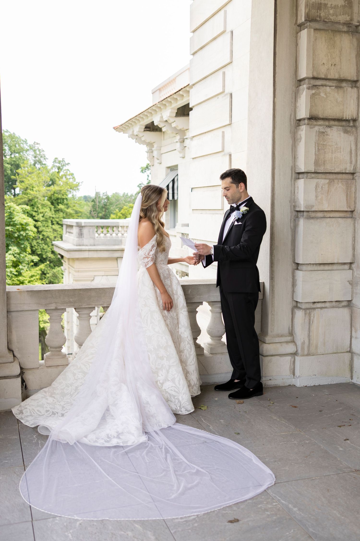 First look wedding photography sequence on elegant stone balcony with architectural details.