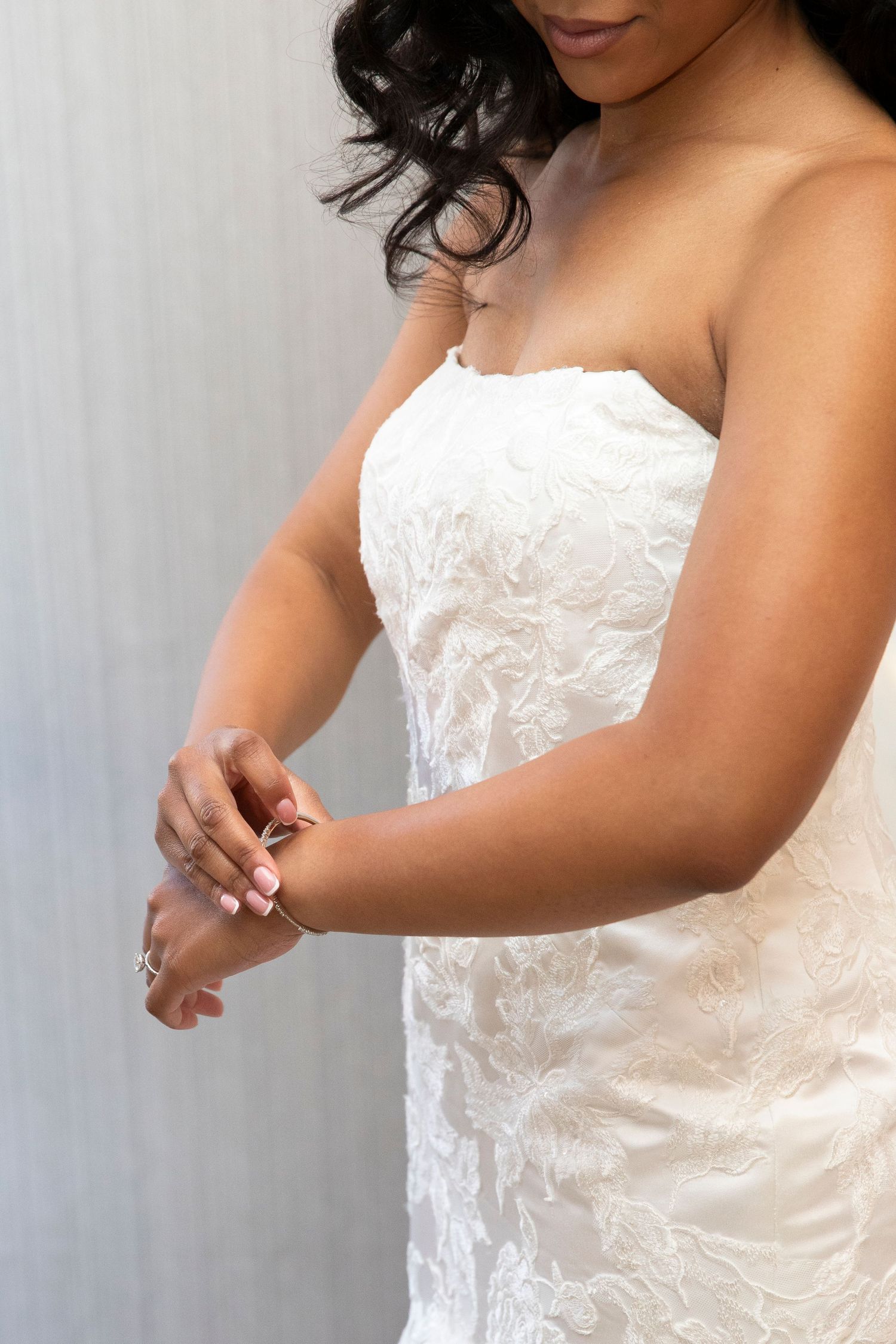 Close-up details of an elegant white lace wedding dress with intricate embroidery patterns.