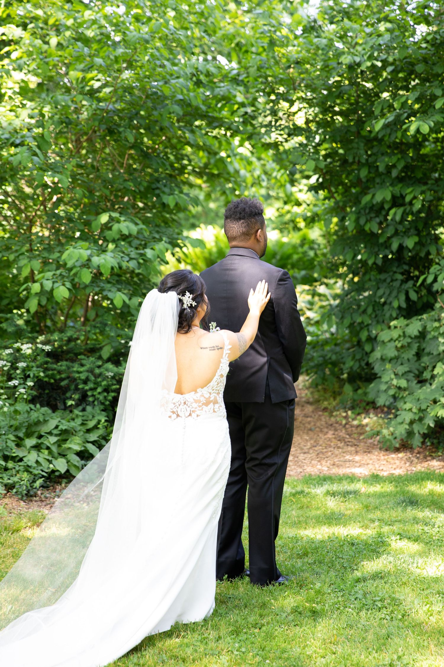 A wedding couple has an intimate first look moment in a lush garden setting.