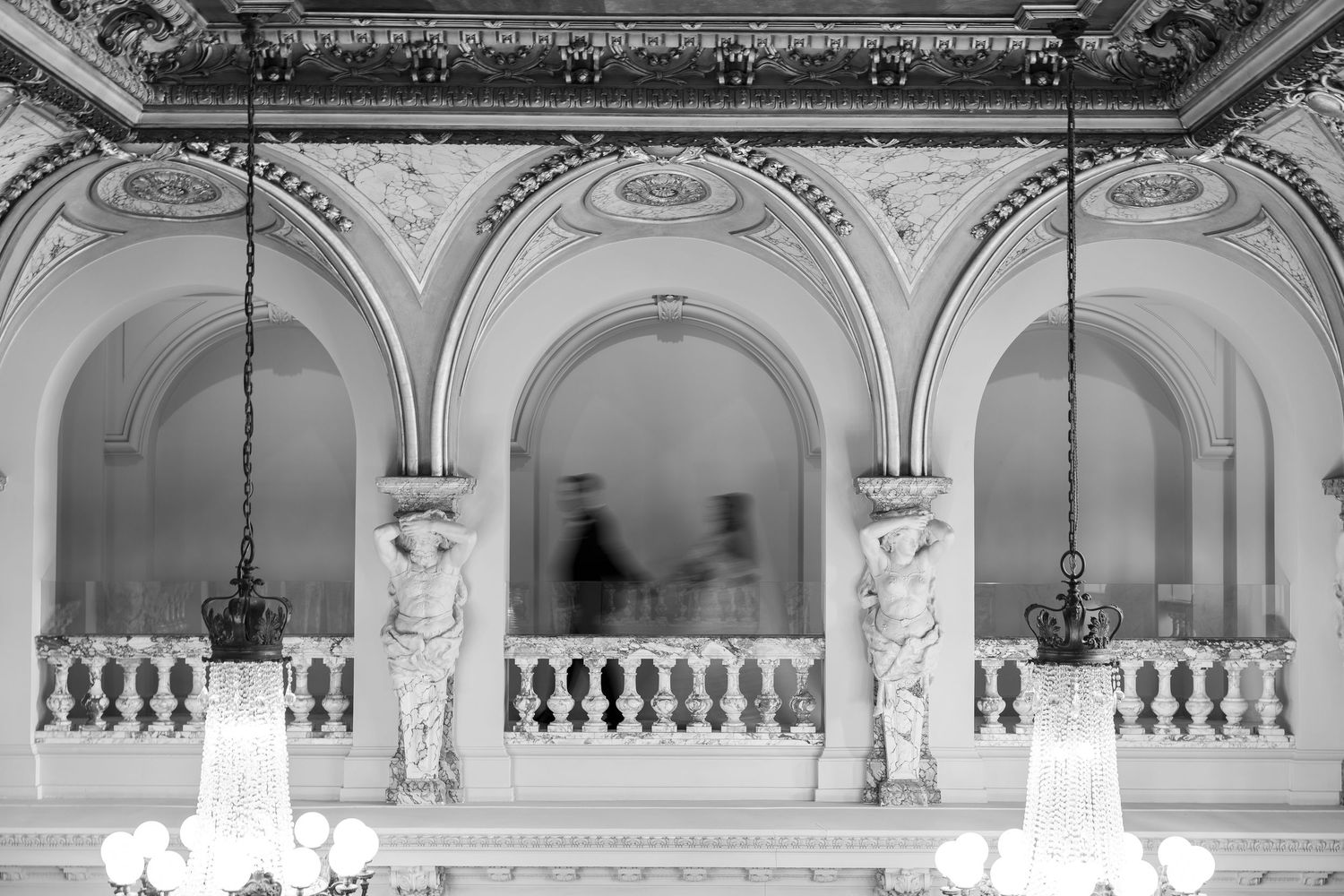 Classical white balcony with decorative columns and arches in an elegant interior setting.