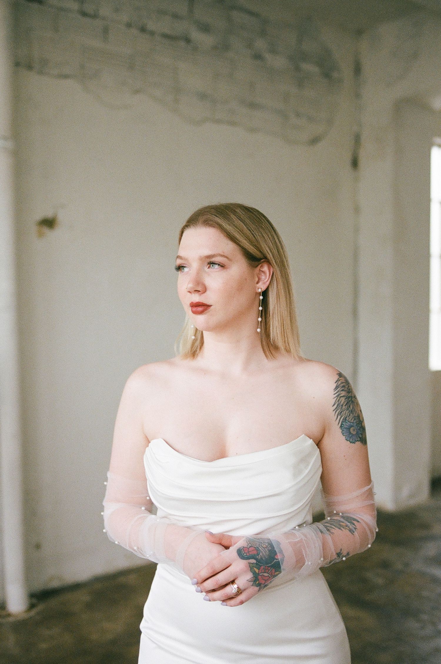 Minimalist studio portraits showing person in white dress against industrial backdrop.