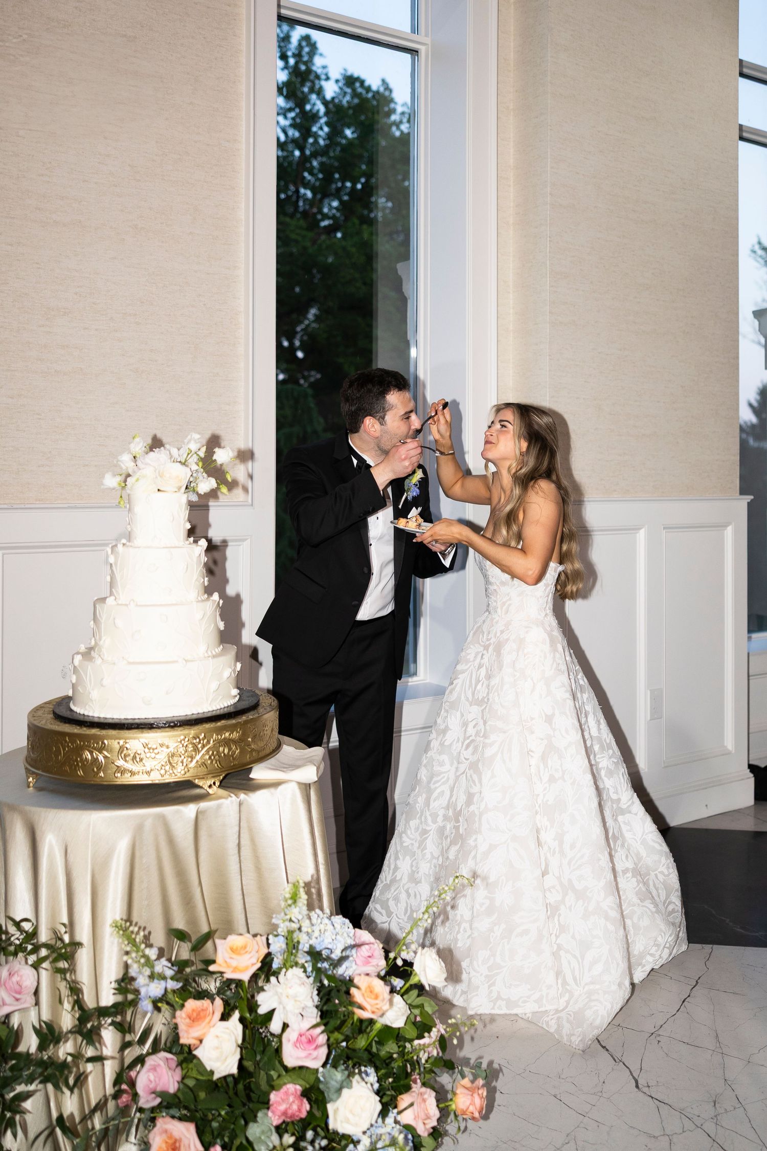 Couple sharing their first bite of wedding cake together.