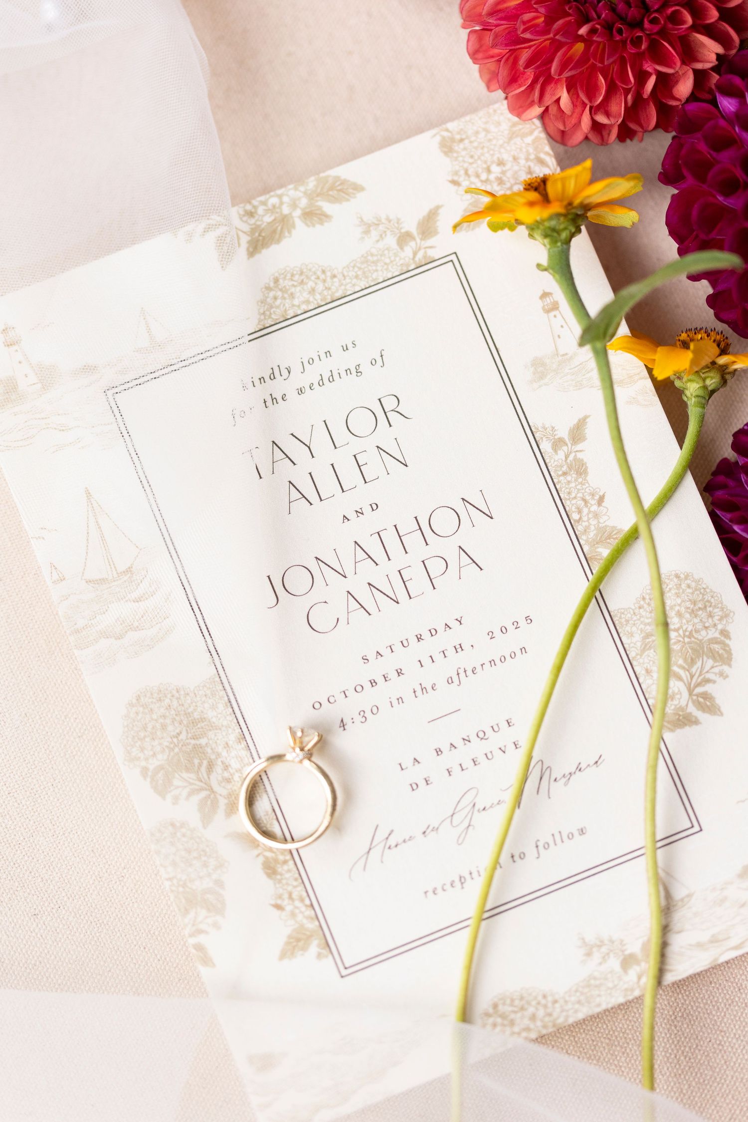 Elegant wedding invitation with floral design and wedding rings displayed with fresh flowers.