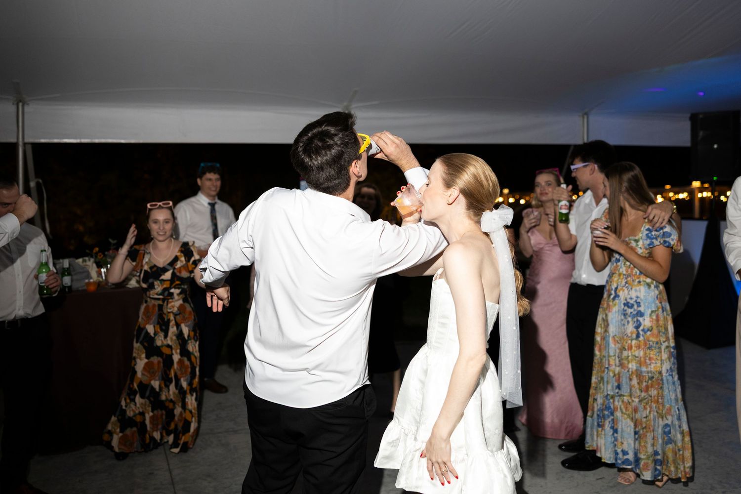 Wedding guests dancing and celebrating on a dark dance floor.