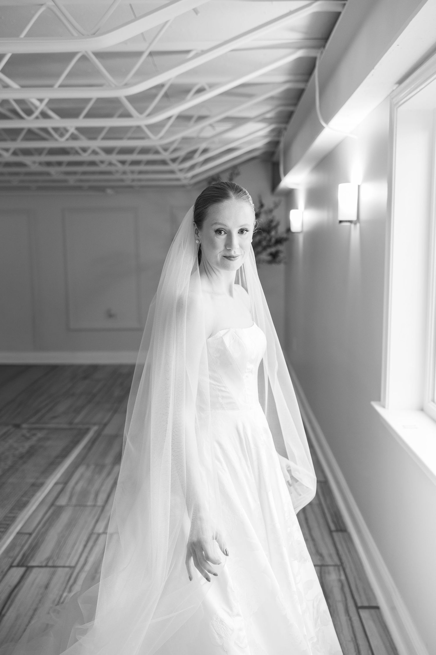 Ethereal bridal portraits with flowing veil in a light-filled studio space.