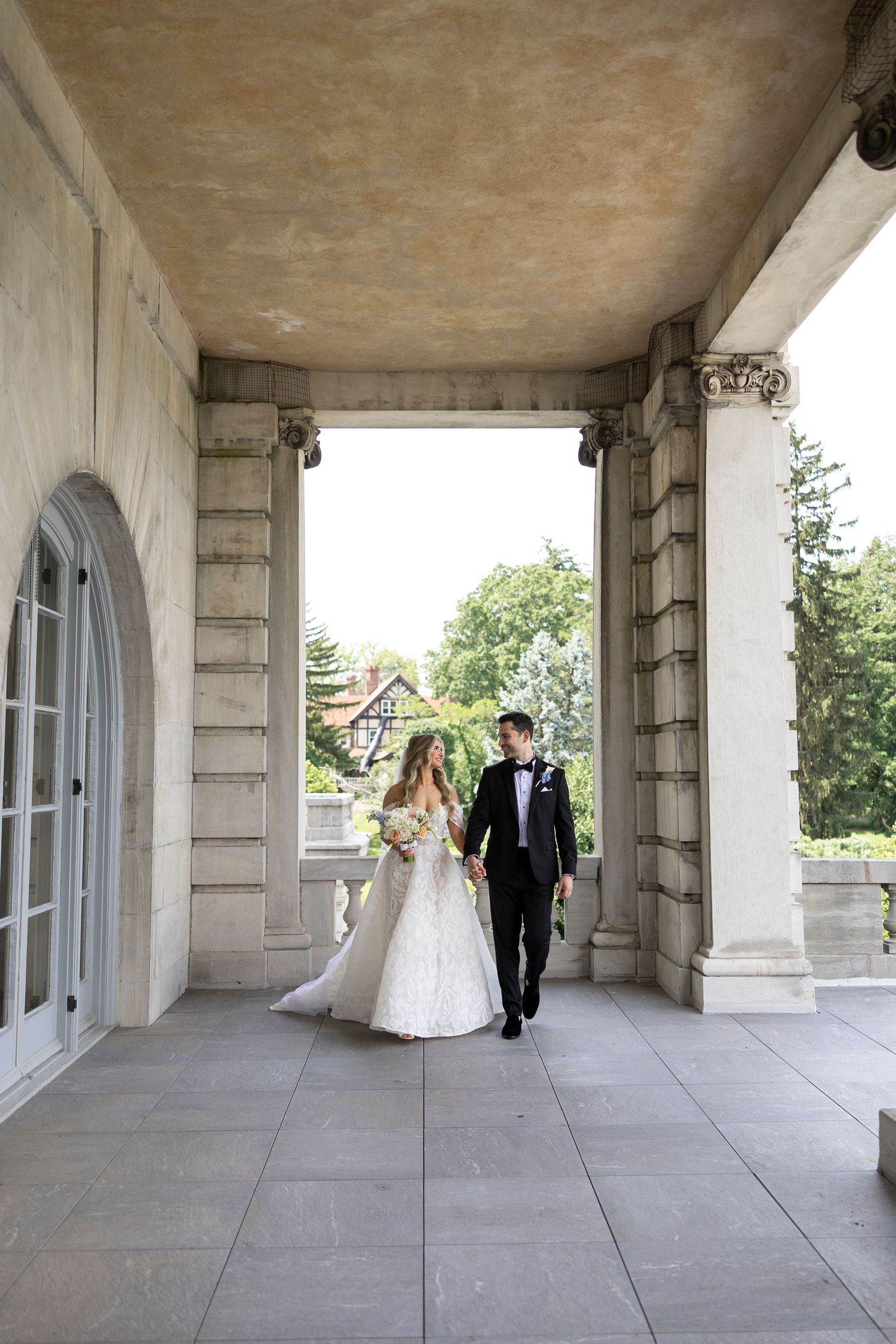 Elegant wedding photography session in a classical stone colonnade.