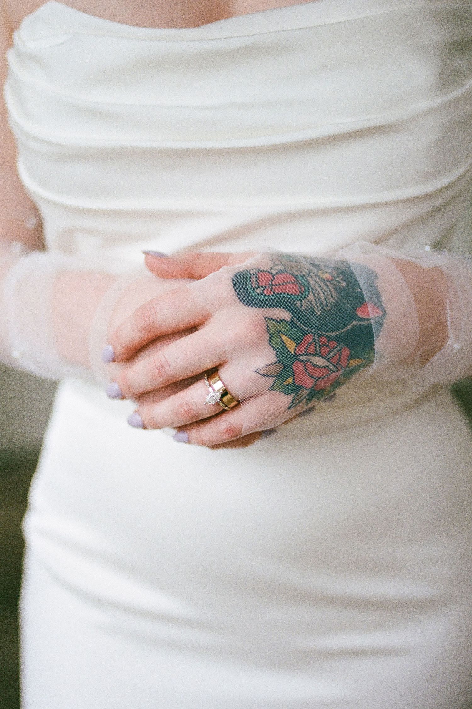 Detail shots of colorful tattoo artwork against white bridal dress fabric.