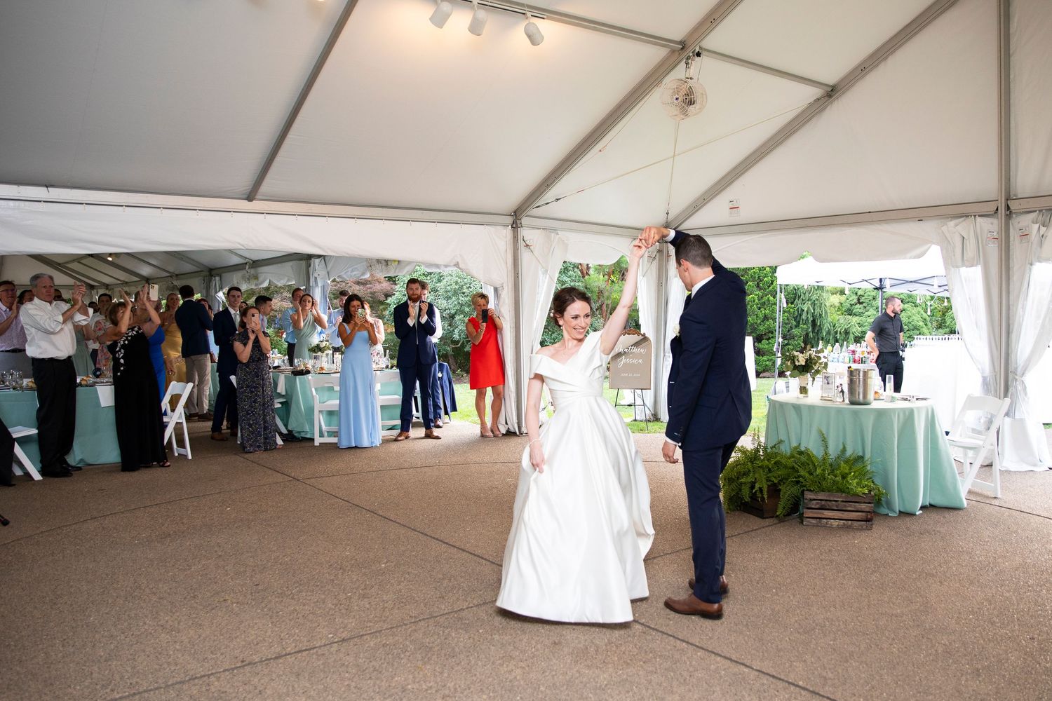 Large white event tent set up for an indoor-outdoor wedding reception.