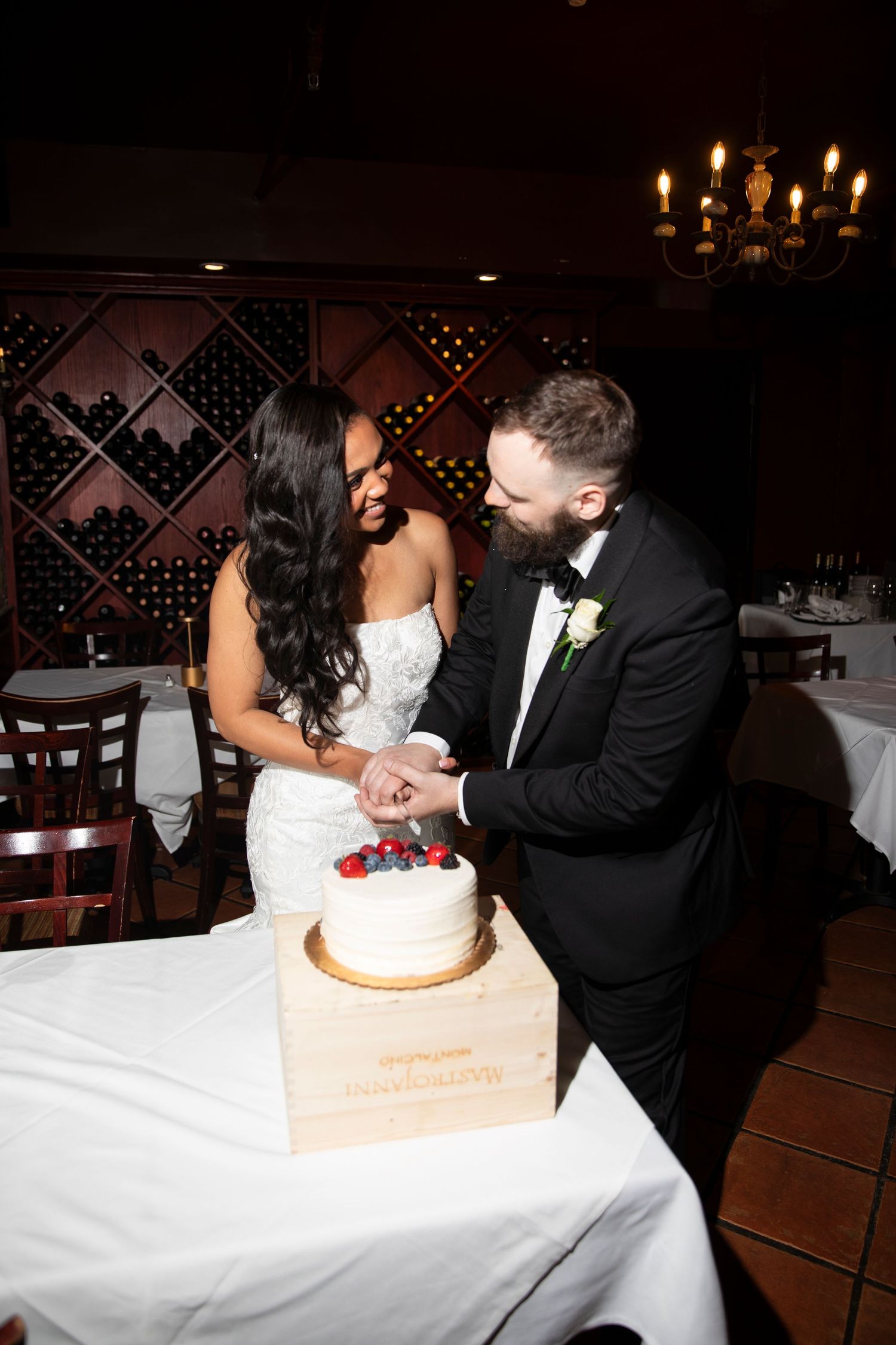 Couple sharing cake-cutting moments at their wedding reception.