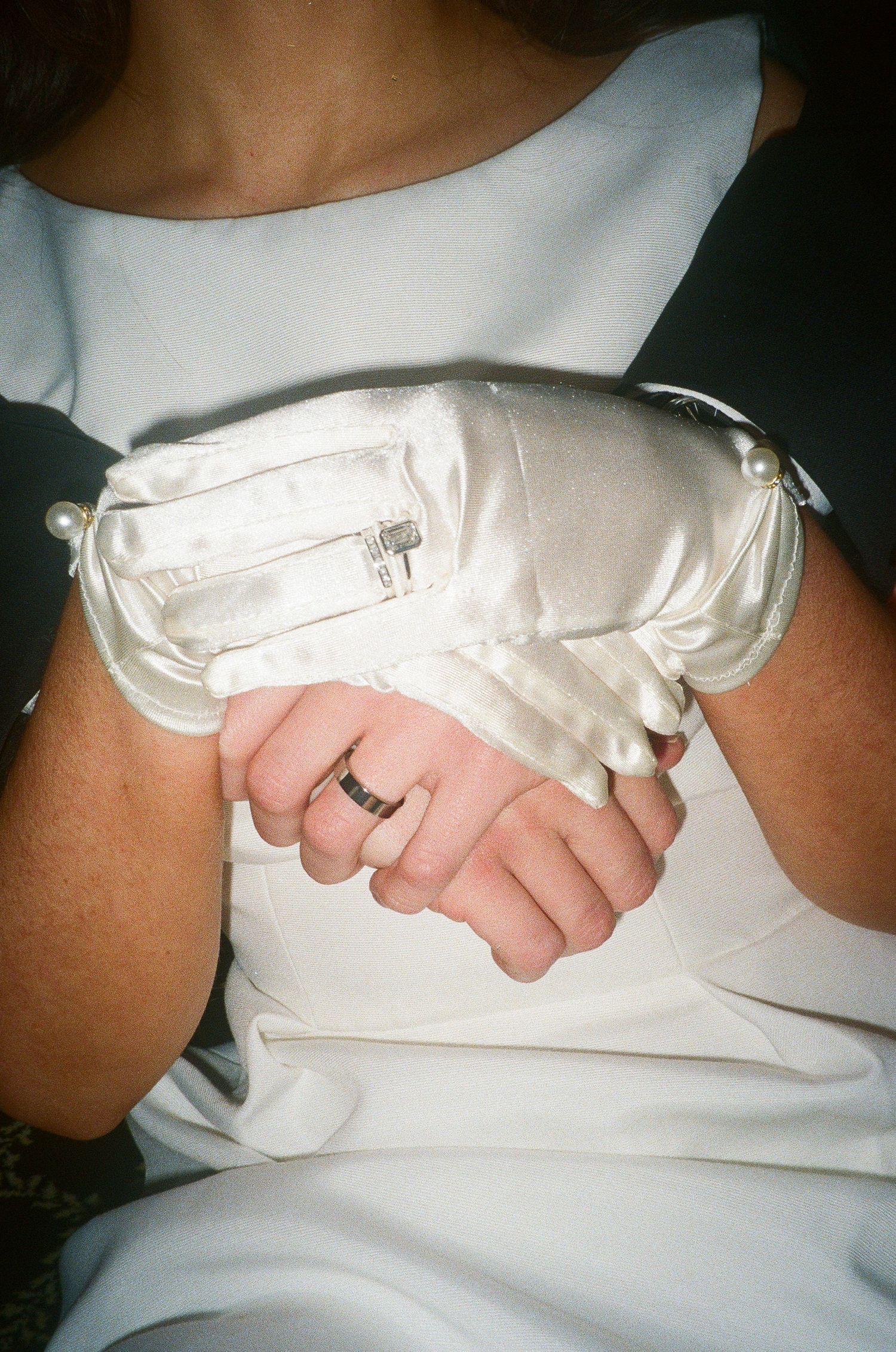 Detail shots of white formal gloves and dress fabric.