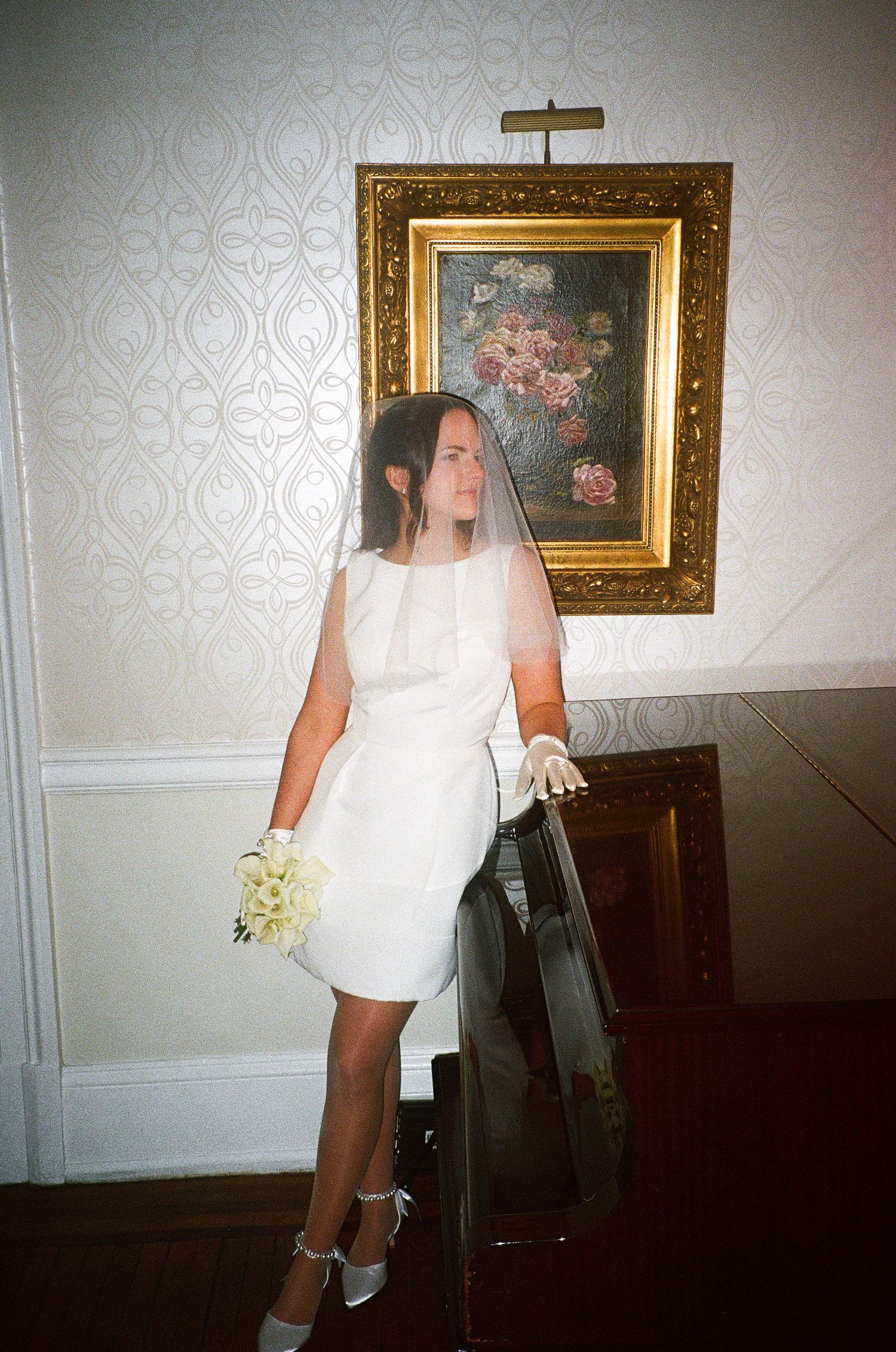 Artistic wedding photography with gold-framed paintings and cross on wall.