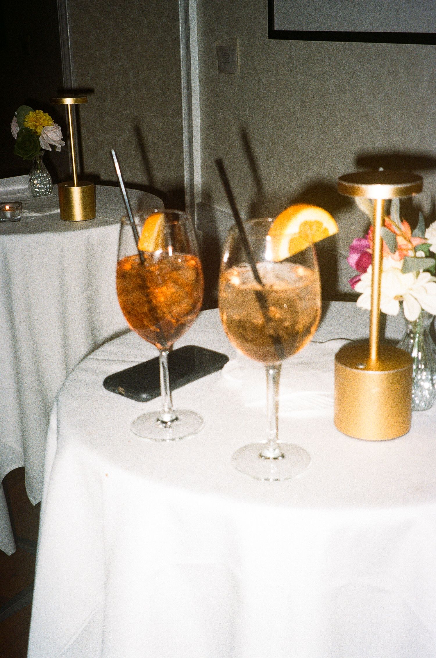 Elegant cocktails and drinks arranged on a white tablecloth at an upscale event.