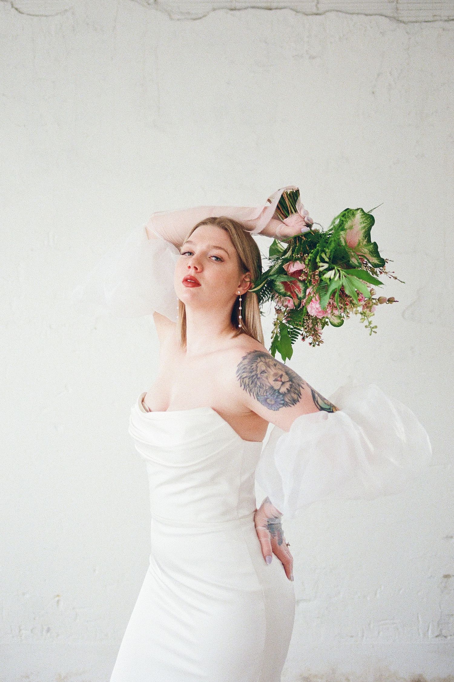 Artistic bridal portraits with greenery and floral elements against white backdrop.